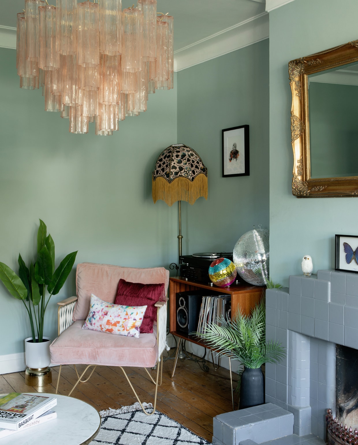 Muurverf Green Blue Farrow &amp; Ball. Hanglamp Sogni Di Cristallo. Stoel, kleed en spiegel Dust (Lisa’s voormalige interieurwinkel). Plantenpotten West Elm. Salontafel Zara Home. Lampenkap Anna Hayman. Lampenvoet en platenkast vintage. Ingelijste vlinders Otherist. Iris Apfel-print Jill &amp; Gill. Overig onbekend. vtwonen special binnenkijker 12-2022 | productie Living Inside | fotografie Ruth Maria Murphy | tekst Marzia Nicolini | tekstbewerking Saskia Borst