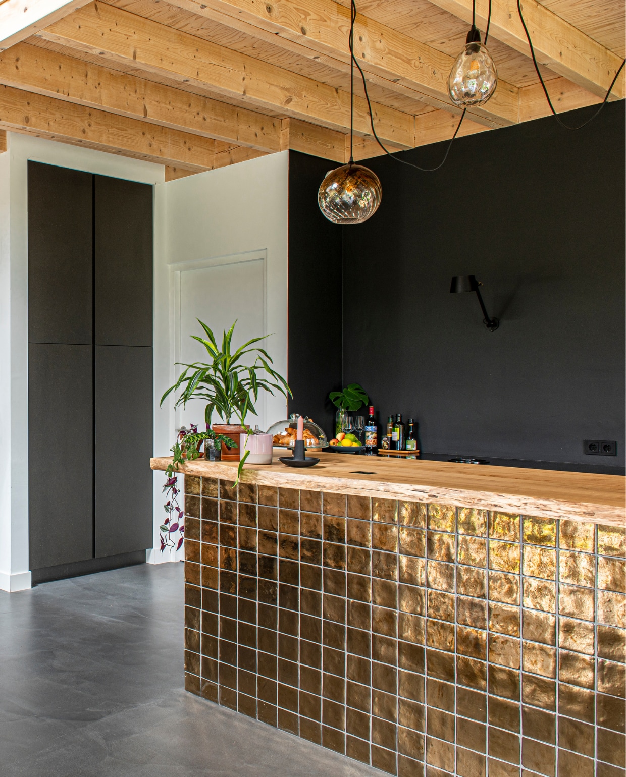 Gouden tegels bar Cottoceramix via Patroonfabriek, keuken en acaciahouten barblad Meubelmakerij Mark, hanglampen Made, zwarte muurlamp Tonone. vtwonen 03-2023 | productie De Binnenkijkers | styling Jeske Weel | fotografie Caroline Coehorst | tekst Chris Muyres