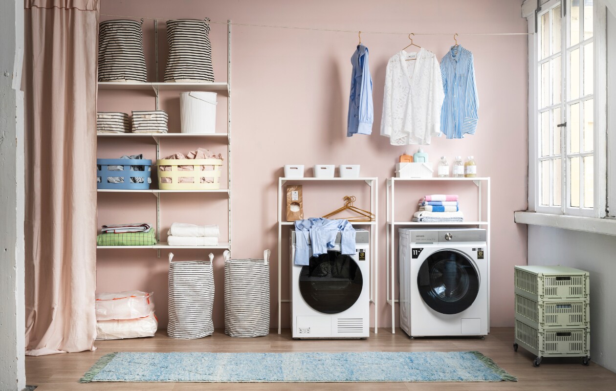 Muurverf no. 837 van Lab Paint, per liter € 48,- (vestingh.nl). Wasmachine Quickdrive € 1149,-, wasdroger Bespoke 9000-serie A+++ energie efficient € 1299,- (samsung.com). Apparatuurombouw, 80x30x129 cm (bxdxh) € 80,-, kast Boaxel, 62x40x201 cm (bxdxh) € 60,20, gordijn met bies Moalisa € 29,99, zwart-wit gestreepte opbergzakken Klunka op de grond € 9,99, plastic opbergzakken met fluorescerende rits Ranen € 3,99, witte handdoeken € 19,99, blauwe en roze dekbedovertreksets met strepen € 29,99, witte opbergbakken € 3,99 (ikea). Blauwe en zachtgele wasmand van Hay, per stuk € 39,-, emmer met deksel van Hachiman € 43,99, witte geribbelde bak met hendels van Hachiman € 28,75, groene geruite plaid van HKliving € 69,95. Bovenin de kast gestreepte manden van House Doctor € 19,99, gestreepte lage opbergmand van Zeller € 9,49 (vtwonen.nl). Groene kratten op wielen € 203,05, gestreepte handdoeken vanaf € 24,70, weefsel met wafeltjespatroon vanaf € 14,-, zachtblauw tafelkleed met fluorescerende rand € 89,- (hay.nl). Kledinghangers, per 4 € 37,95, vloerkleed € 570,- (hkliving.nl). Wasmiddel en wasverzachter € 6,95, zeepvlokken € 9,95 (dille-kamille). Blouses tweedehands (vintagebrands.eu). vtwonen 04-2023 | styling Marianne Luning | fotografie Stan Koolen | assistentie Paul Blom, Kelly van Gendt