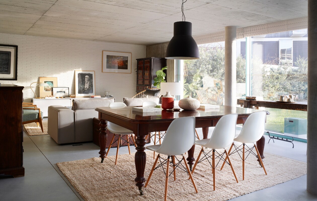 Antieke eettafel. Stoelen Eames DSW. Potjes op tafel Zara Home. Hanglamp en kleed Ikea. zetel en lage kast tegen de muur, beide ontworpen door Marta. De kunstwerken aan de muur en links op lage kast zijn gemaakt door Marta’s oom Bartolomeu Cid dos Santos. Groot zwart-wit kunstwerk rechts op lage kast, Sainer. Blauwe fauteuils vintage. Hoge kast antiek. vtwonen 05-2020 | styling Alison Cavanagh | fotografie Rachael Smith