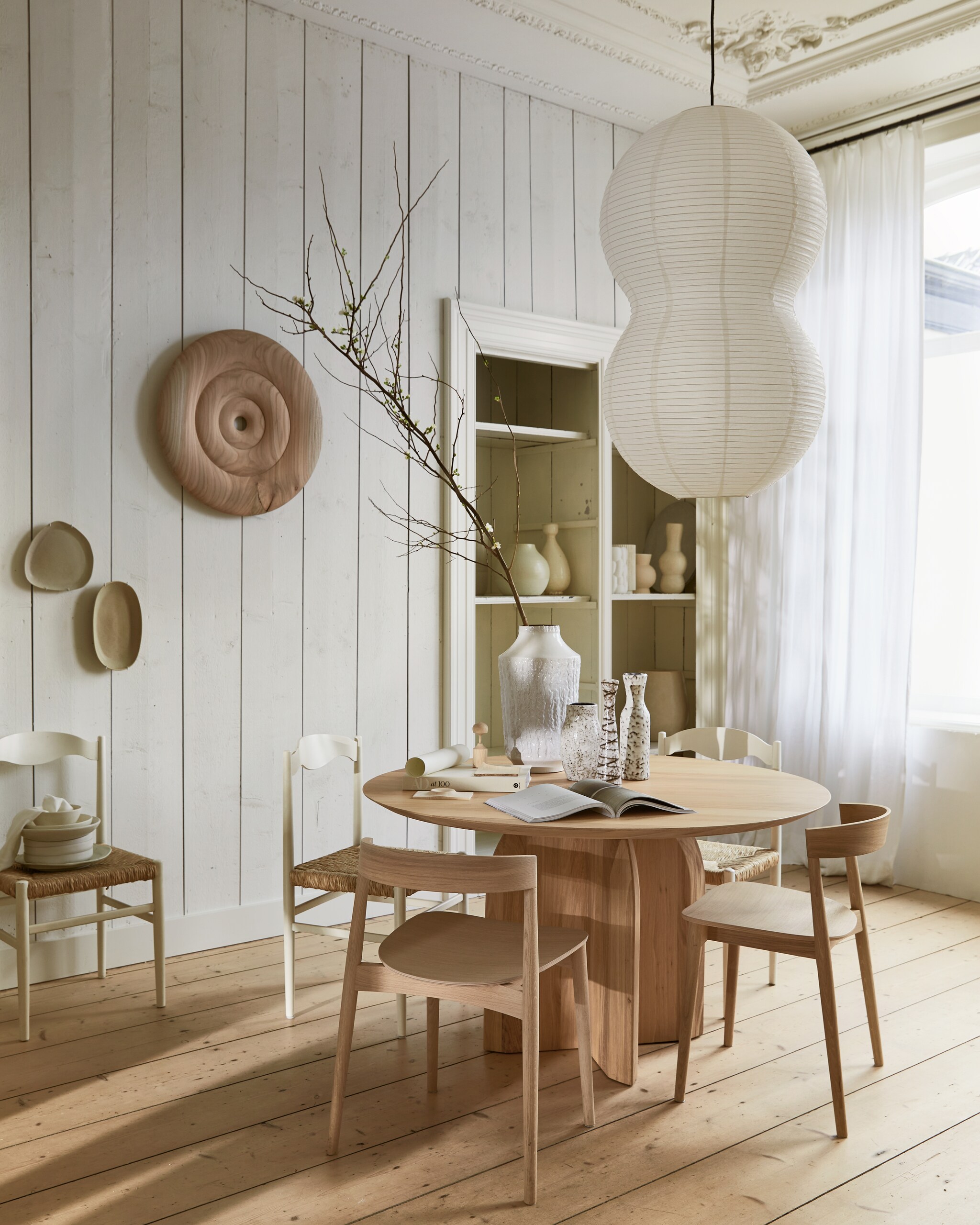 Eikenhouten eettafel Slot Quadpod, circulair design, 140x74 cm (Øxh) vanaf € 3669,- (studio-henk.nl). Eikenhouten eetkamerstoel Kite vanaf € 590,- (bolia.com). Papieren hanglamp Puff Twist van Normann Copenhagen, 50x90 cm (Øxh) € 85,- (groenenakker.nl). Vintage vazen vanaf € 25,- (vandijkenko.nl). Vintage stoelen met koordzitting, set van 6 € 500,- (vintagehoarder.com). Ronden houten objecten aan de muur en op tafel, prijs op aanvraag (rubenvdscheer.nl). Tadelakt vazen in de kast vanaf € 115,-, borden vanaf € 29,- (householdhardware.nl). Organisch keramieken bord aan de muur, prijs op aanvraag (marjokedeheer.com). Ovalen schaal aan de muur € 67,- (bungalow.dk). Overig privébezit. vtwonen 04-2023 | styling Cleo Scheulderman | fotografie Jeroen van der Spek