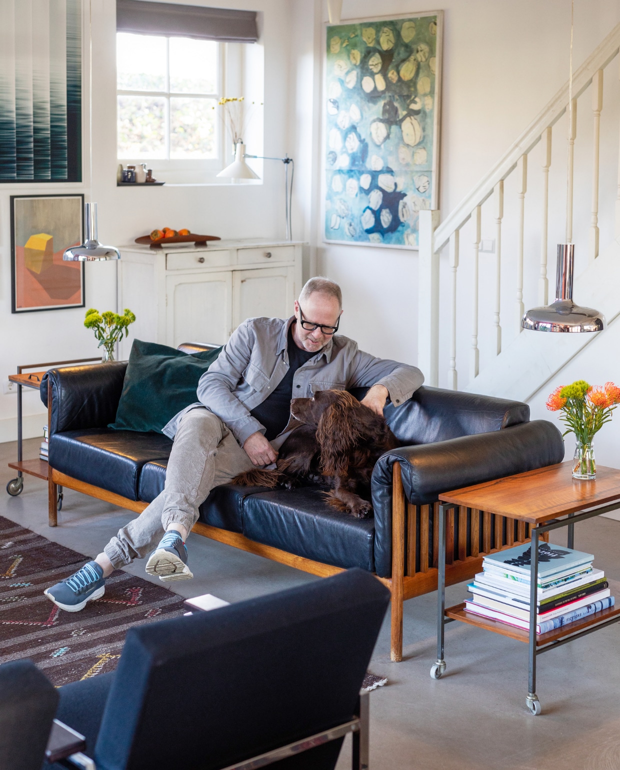 Bank Johannes Andersen voor CFC Silkeborg, hanglampen Bentler of Birkerød via Vaen, stoelen Model 30 van Gijs van der Sluis via Morentz, bijzettafels en fruitschaal Vintage Asylum, vloerlamp Anvia, kast vintagemarkt, kussens Fést Amsterdam, vazen kringloopwinkel, vloerkleed Kilim. Kunst: links boven Jannemarein Renout via Galerie Bart Amsterdam, links onder Sara Oliveira Martins, rechts Hans Schabracq. Muur- en houtverf in Quiet Blush van Lab Paint van Vestingh. vtwonen 03-2023 | Styling Ilona Jongepier | Fotografie Dana van Leeuwen