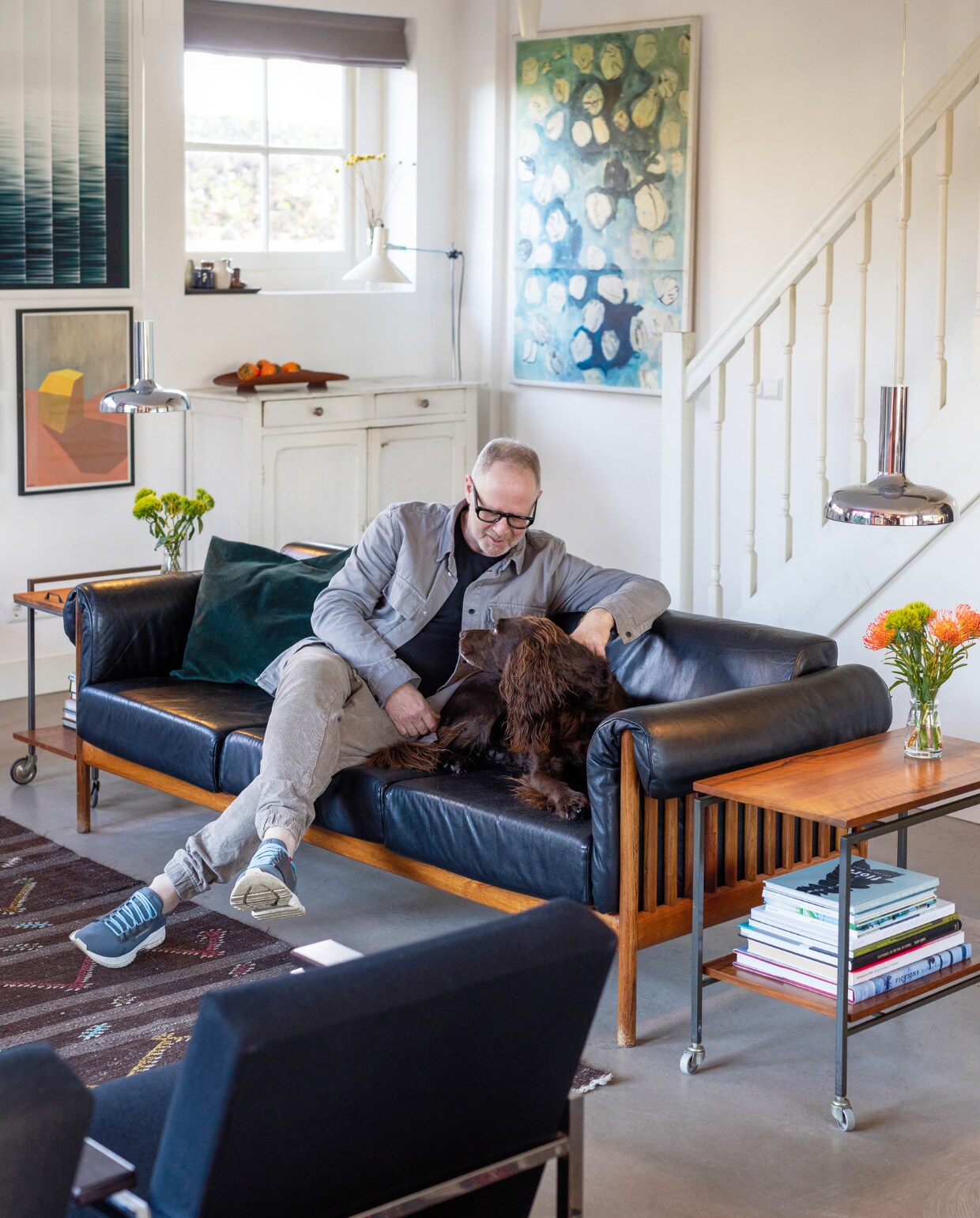 Bank Johannes Andersen voor CFC Silkeborg, hanglampen Bentler of Birkerød via Vaen, stoelen Model 30 van Gijs van der Sluis via Morentz, bijzettafels en fruitschaal Vintage Asylum, vloerlamp Anvia, kast vintagemarkt, kussens Fést Amsterdam, vazen kringloopwinkel, vloerkleed Kilim. Kunst: links boven Jannemarein Renout via Galerie Bart Amsterdam, links onder Sara Oliveira Martins, rechts Hans Schabracq. Muur- en houtverf in Quiet Blush van Lab Paint van Vestingh. vtwonen 03-2023 | Styling Ilona Jongepier | Fotografie Dana van Leeuwen