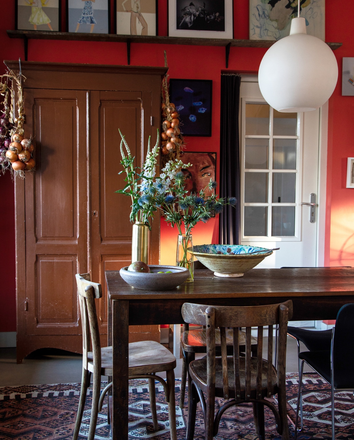 Tafel Jan van IJken, caféstoelen Burbri, stoel rechts 40/4 van David Rowland via Tim Tom, hanglamp Satellite van Vilhelm Wohlert via De Vreugde Design, kast vintagemarkt, schaal links vintage, schaal rechts Polspotten, metalen vaas Zara Home, glazen vaas Loods 5, vloerkleed Kilim. Kunst: op plank Piet Paris, midden Louise te Poele voor Claudia Sträter, rechts Hans Schabracq, tussen kast en deur boven Louisiana van Onna, onder Anthony Cudahy. Muurverf Shocking Coral, houtverf Quiet Blush, beide Lab Paint van Vestingh. vtwonen 03-2023 | Styling Ilona Jongepier | Fotografie Dana van Leeuwen