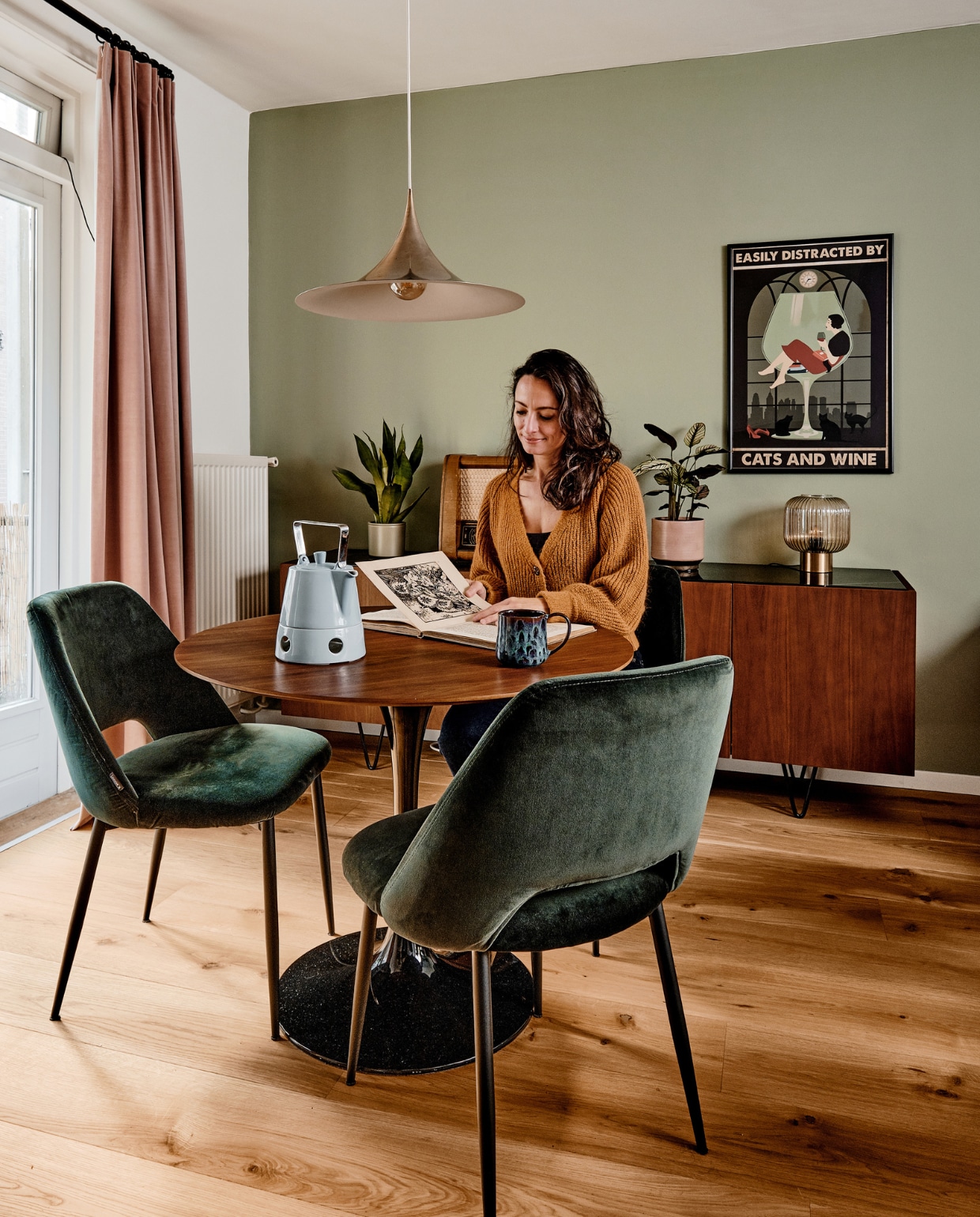 Vloer eiken lamelparket van Stox, muurverf Jofel van Praxis, gordijnen Veneta. Eettafel en stoelen Loods 5, theepot Arzberg, mok kringloop. Dressoir Furnified, bloempotten De Balkonie, radio erfstuk opa, lamp Van Ons, schilderij Tagotee. vtwonen 02-2021 | productie Coco Features | fotografie Roos Oosterbroek