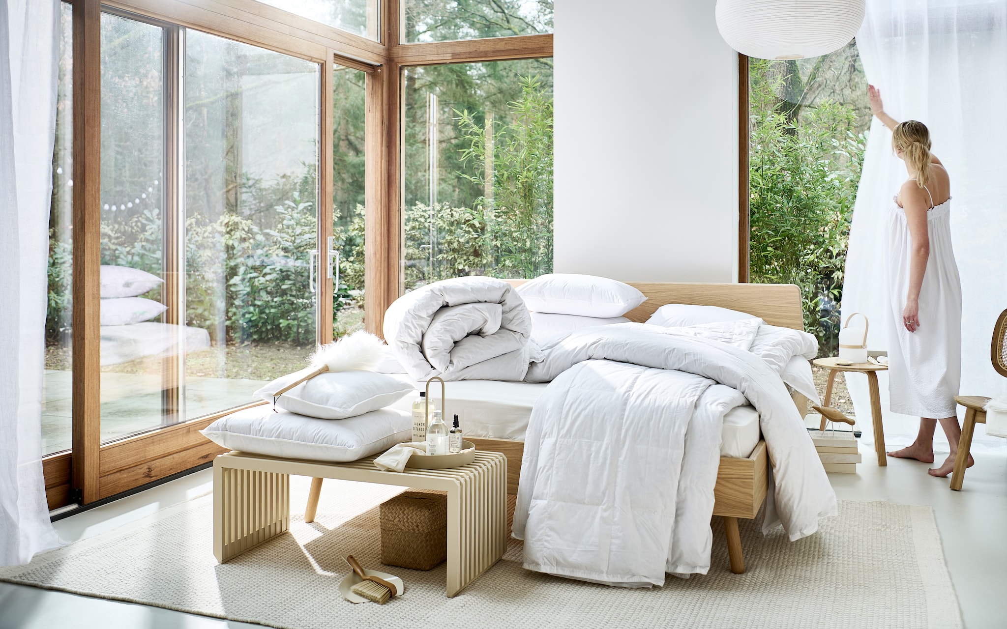 Diverse onderdelen uit de beddengoedcollectie Dixxius by vtwonen. M.m.v. loof.nl (houten bed Basket), vtwonen.nl (beige bank van HKliving, vloerkleed van Linie Design, fauteuil van Kave Home, houten bijzettafel van Hay, dienblad met handvat van Ferm Living, houten vogel van Vitra, witte hanglamp van Hay), dille-kamille.nl (rieten mand met deksel, wasverzachter, kussenspray, witte schaal), zarahome.com (stoffer en blik, plumeau, tafellamp, wit gordijn, wasmiddel, witte plaid, zijden slaapmasker). Overig privébezit. vtwonen 04-2023 | productie Tanja Saarberg | styling Sanne Ketelaar | fotografie Sjoerd Eickmans | assistentie Esmee Jacké