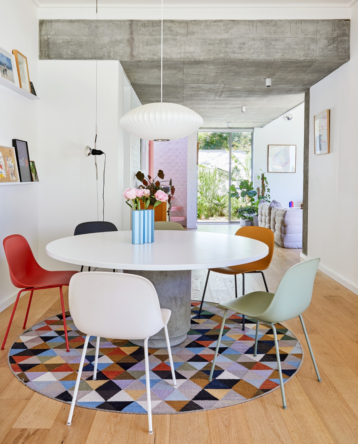 Tafel zelfgemaakt. Stoelen Muuto. Vaas Nuage Vitra. Hanglamp Bubble George Nelson. Vloerkleed True Design. Zwarte lamp Parentesi Flos. vtwonen special binnenkijken 2022 | productie Luanne Toms | fotografie Greg Cox/Frank Features
