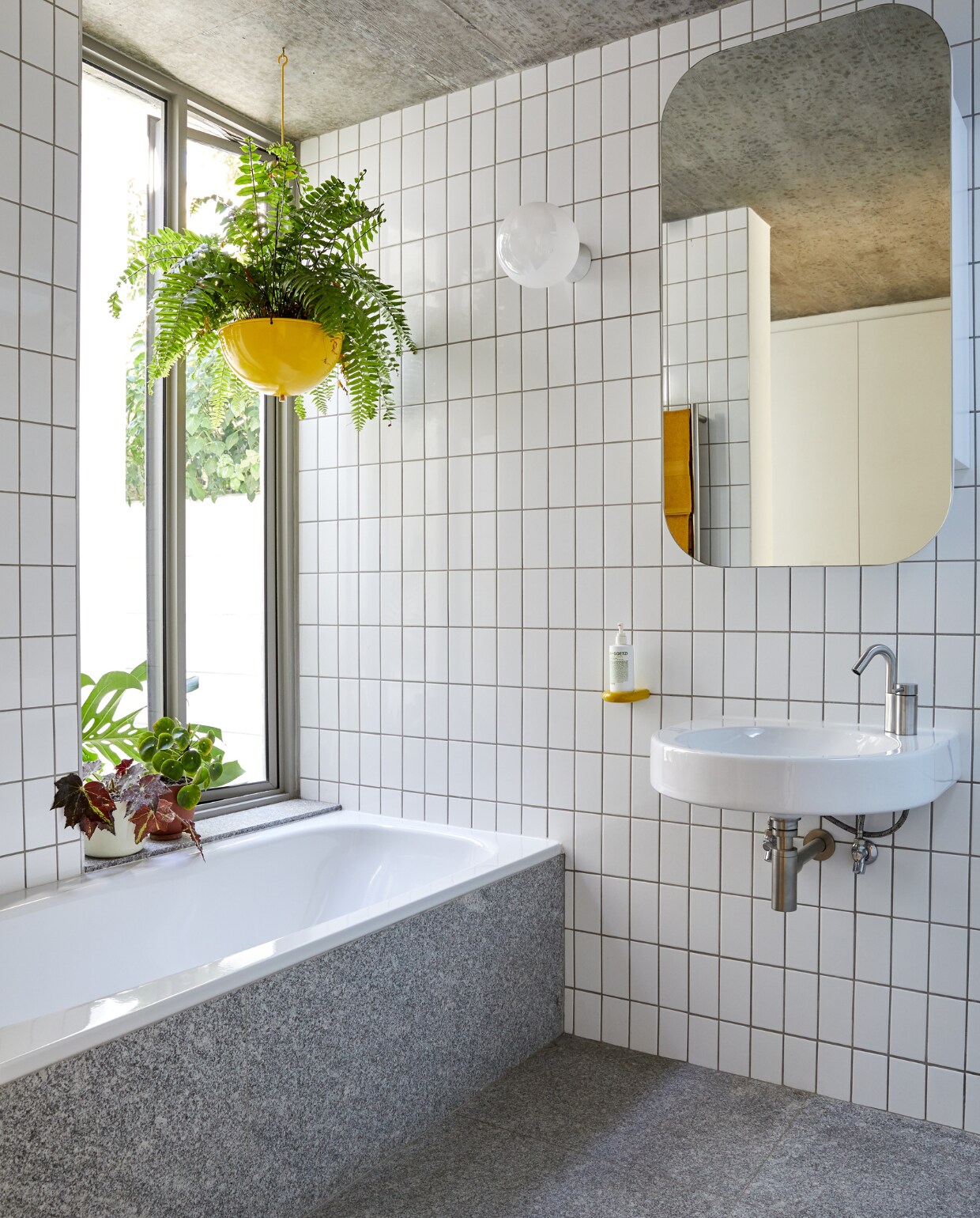 Tegels en spiegel bouwmarkt. Vloertegels Rustenberg. Wastafel Architec Duravit. Kraan Ottavo Quadro Design. Plantenpot Pedersen &amp; Lennard. Gele pomphouder System 111 Hewi. vtwonen special binnenkijken 2022 | productie Luanne Toms | fotografie Greg Cox/Frank Features