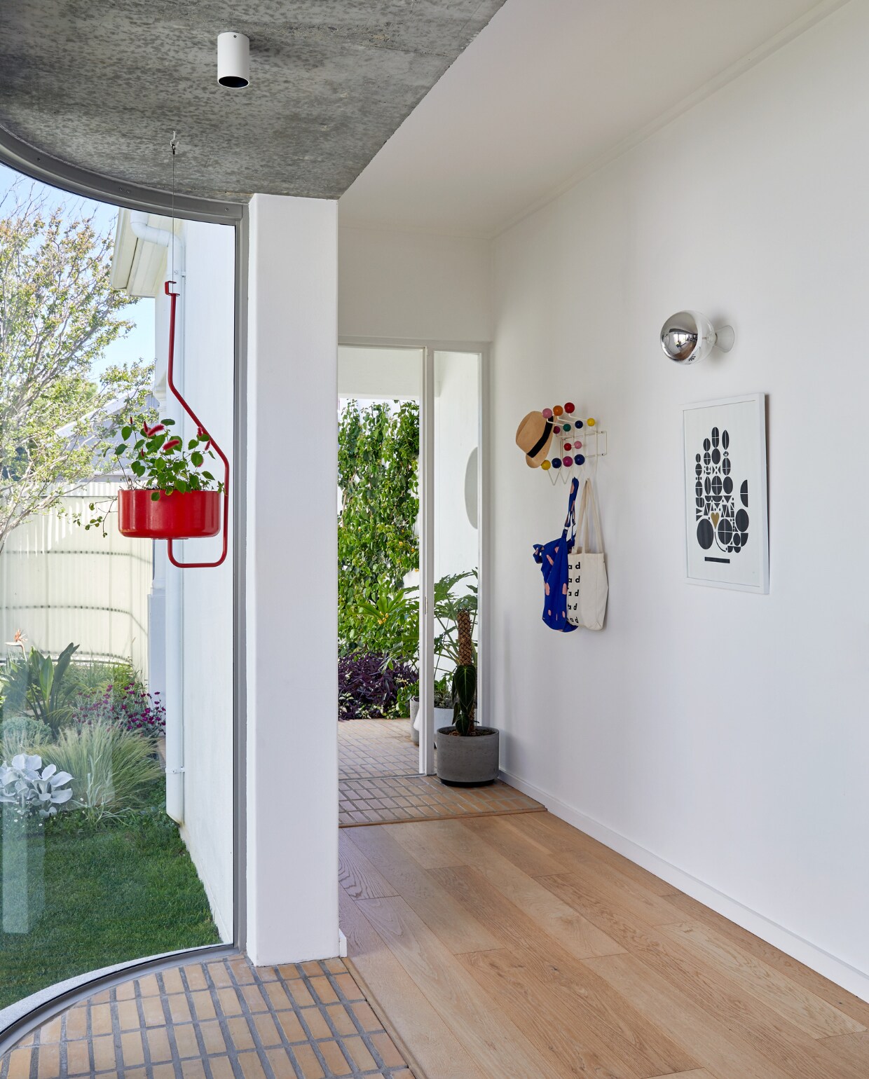 Rode plantenpot Ridge Forrester Joe Paine. Kapstok Hang it All van Eames. Wandlamp Zangra. vtwonen special binnenkijken 12-2022 | productie Luanne Toms | fotografie Greg Cox/Frank Features