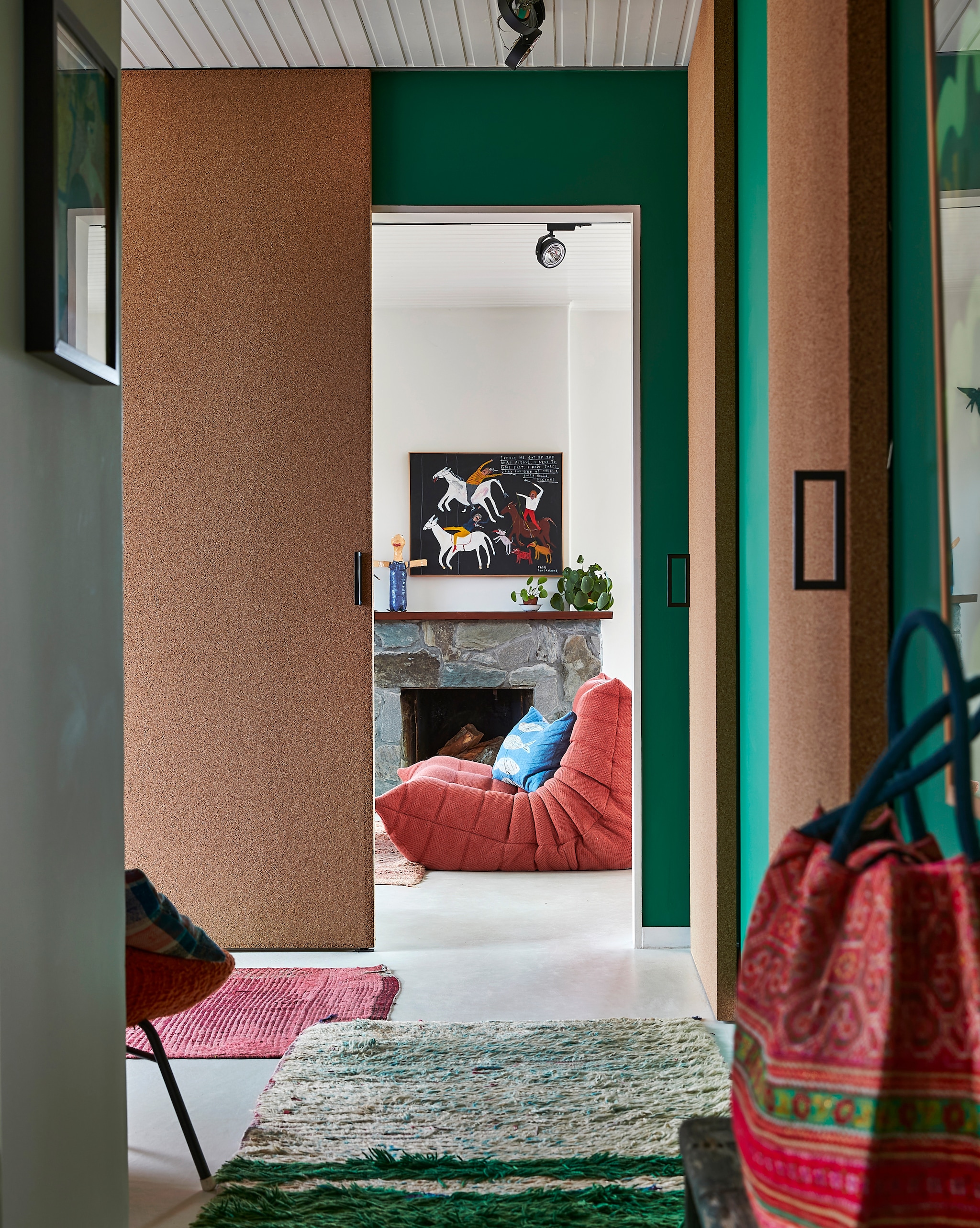 Muurverf Ressource. Kurkdeuren op maat gemaakt. Bank Togo Ligne Roset. Blauw kussen zelfgemaakt. Schilderij uit Engeland. Pop op de schouw bewaard knutselwerk van Ginger. Kleden uit Marokko. Rieten tas uit Thailand. vtwonen special binnenkijken 2022 | productie Living Inside | fotografie Jan Verlinde