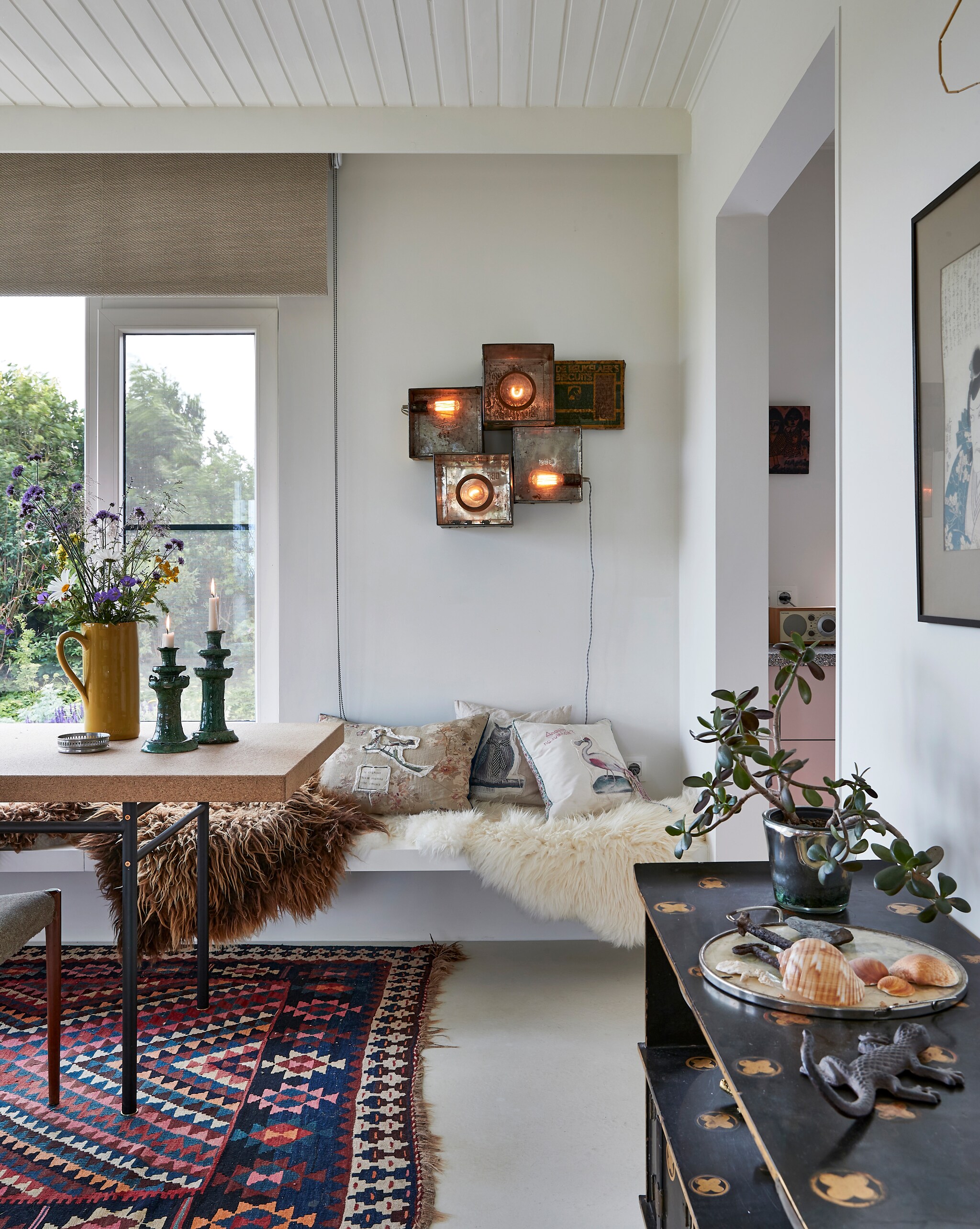 Wandlamp Zoé Morel. Kandelaars uit Marokko. Kussens zelfgemaakt. Kastje familiestuk. Dienblad rommelmarkt. Vloerkleed uit Istanboel. vtwonen special binnenkijken 12-2022 | productie Living Inside | fotografie Jan Verlinde