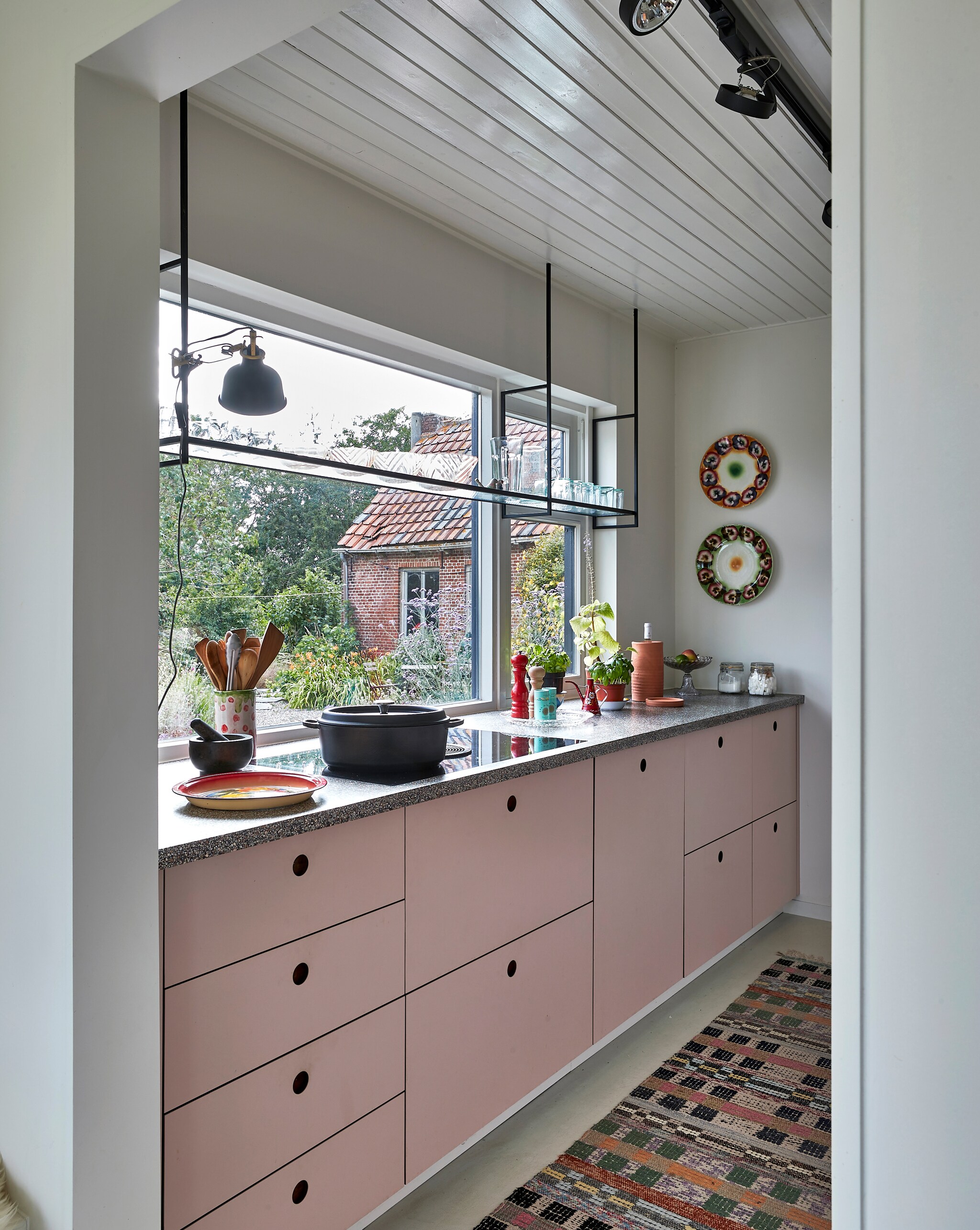 De zelfgemaakte keuken heeft een granitoblad op maat. Zweeds voddenkleed vintage. Wandborden uit Rusland. Overig onbekend. vtwonen special binnenkijken 12-2022 | productie Living Inside | fotografie Jan Verlinde