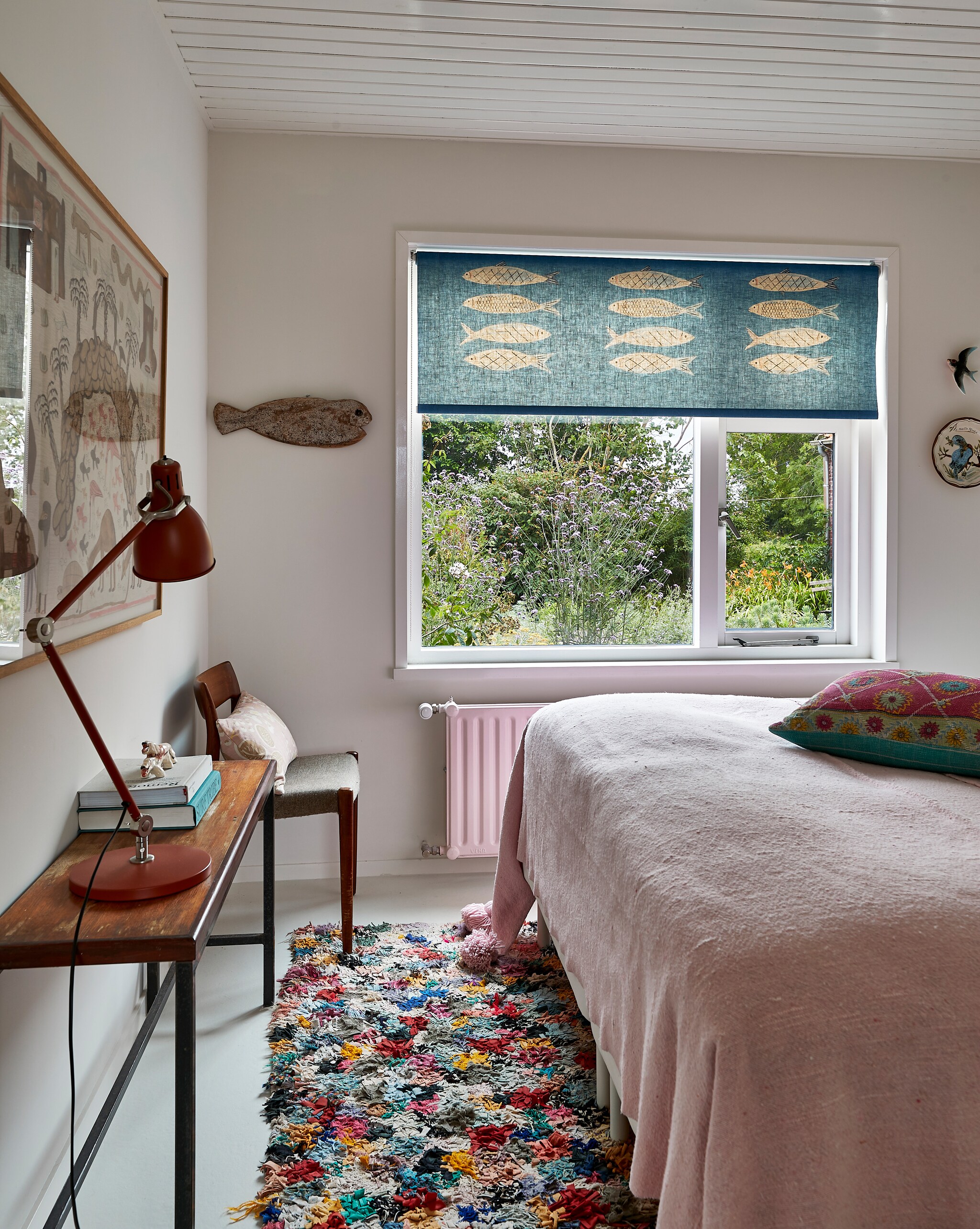 Rolgordijn en kussen op bed zelfgemaakt. Sprei, vloerkleed en ingelijst schilderij uit Marokko. Sidetable van de vorige bewoners. Lamp Ikea. Houten stoel familiestuk. Vis uit Zanzibar. vtwonen special binnenkijken 12-2022 | productie Living Inside | fotografie Jan Verlinde