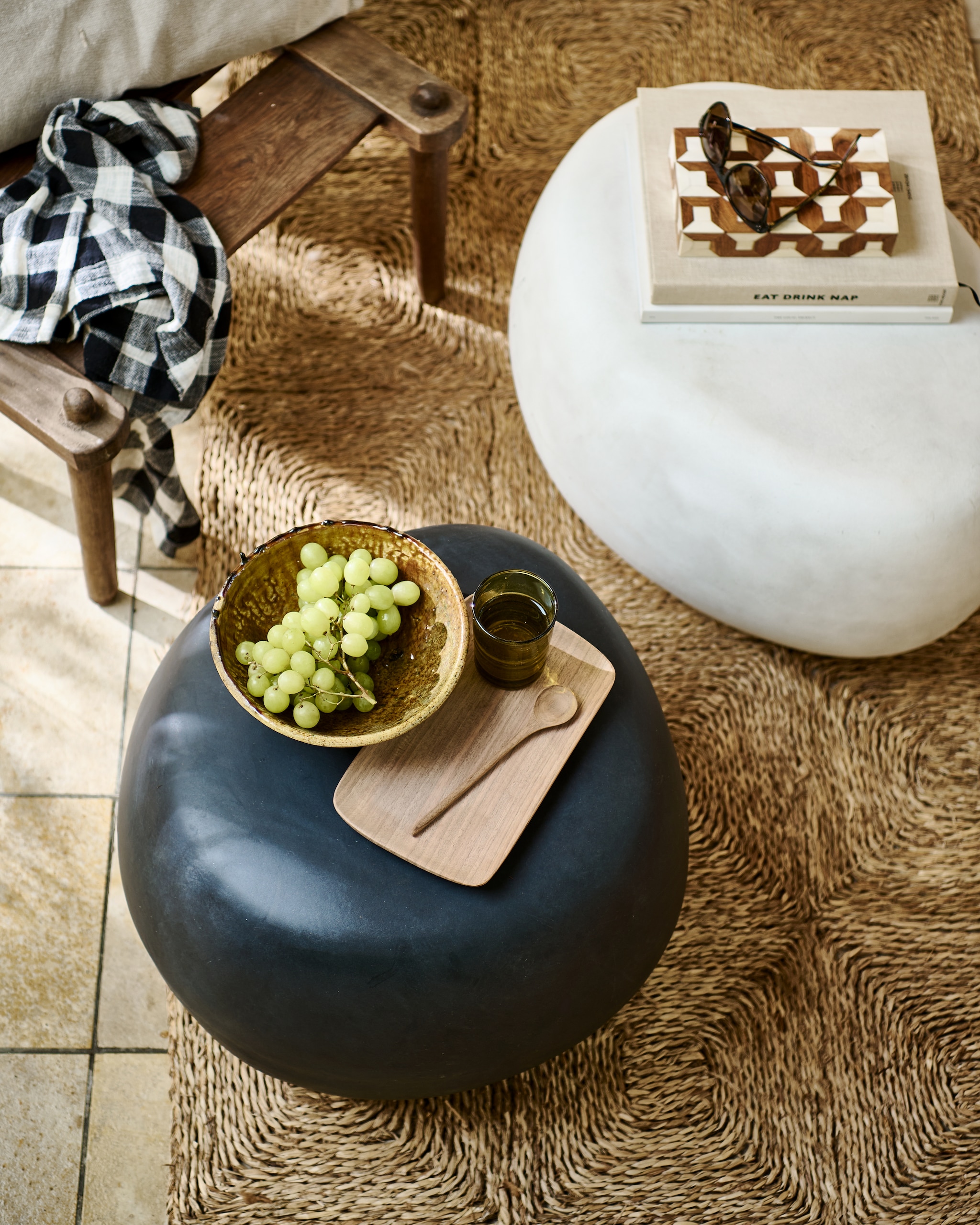 Bijzettafel Pebble in betonlook antraciet, 50x35 cm (Øxh) € 179,-. Bijzettafel Pebble in betonlook wit, 65x49x31 cm (bxdxh) € 199,-. M.m.v. householdhardware.nl (okergele Tamegroute schaal, walnoothouten dienblad en lepel, waterglas). Overig privébezit. vtwonen 04-2023 | productie Tanja Saarberg | styling Marlies Does | fotografie Sjoerd Eickmans