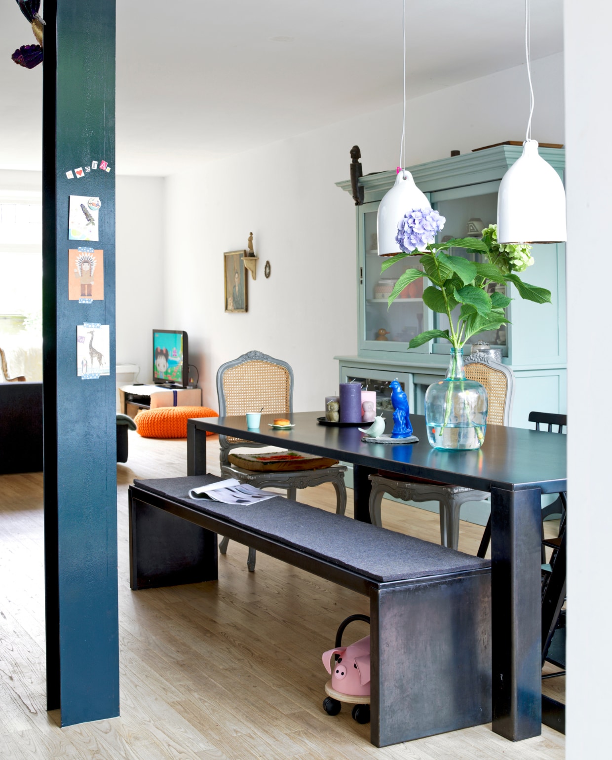 De zwarte, stalen eettafel en het bijbehorende bankje van een winkel op het KNSM-eiland in Amsterdam. Houten stoelen, kringloopwinkel. Kast, Rivièra Maison via Marktplaats zelf geschilderd. De witte hanglampen, The Frozen Fountain. vtwonen 07-2014 | stying Inge van Lieshout | fotografie Louis Lemaire - Inside Homepage