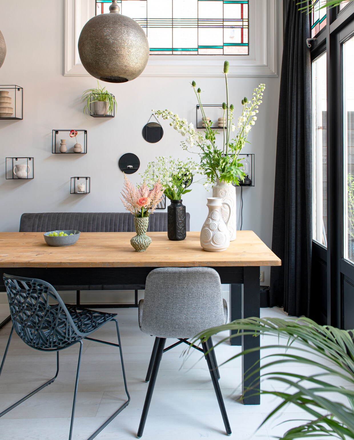 Eettafel uit Frankrijk, eetkamerstoelen en eetkamerbank Loods 5, bloemen Wim van Assem Bloembinderij, hanglampen Zenza Home, wandrekken vtwonen, fruitschaal Xenos, vazen vintage, houtverf kozijnen Ral 9005, muurverf Ral 9003. Overig onbekend. vtwonen 04-2023 | productie De Binnenkijkers | styling Jeske Weel | fotografie Caroline Coehorst