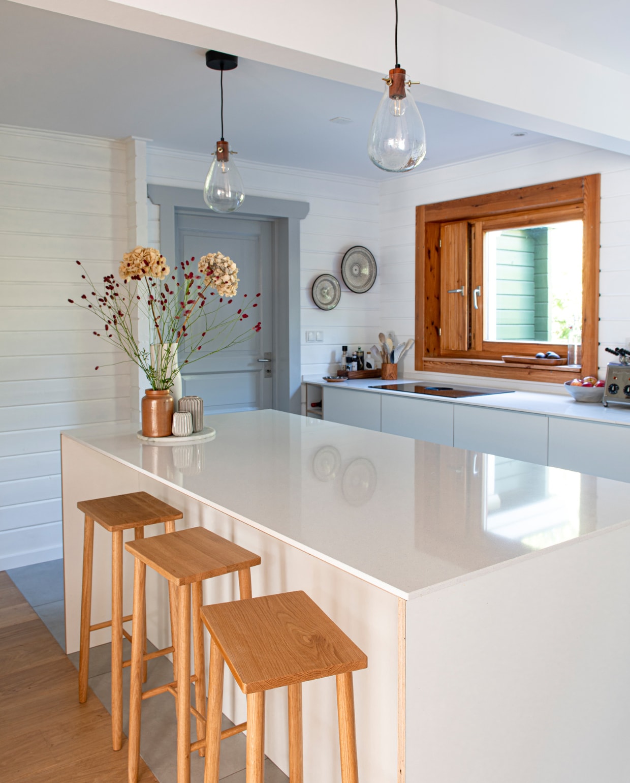 Vloertegels Tegels in Huis, keuken eigen ontwerp, barkrukken Hübsch, hanglampen H&amp;M Home, grijze verf Ncs s 2000-n hoogglans, borden uit Marokko. Schaal met vazen Cin in Wonen, kringloopwinkel en YaYa. Houten bak H&amp;M Home, plank uit Bali, keramische schaal Amaï. Kookplaat Bora, tosti-ijzer Milan. vtwonen 04-2023 | productie De Binnenkijkers | styling Jeske Weel | fotografie Caroline Coehorst