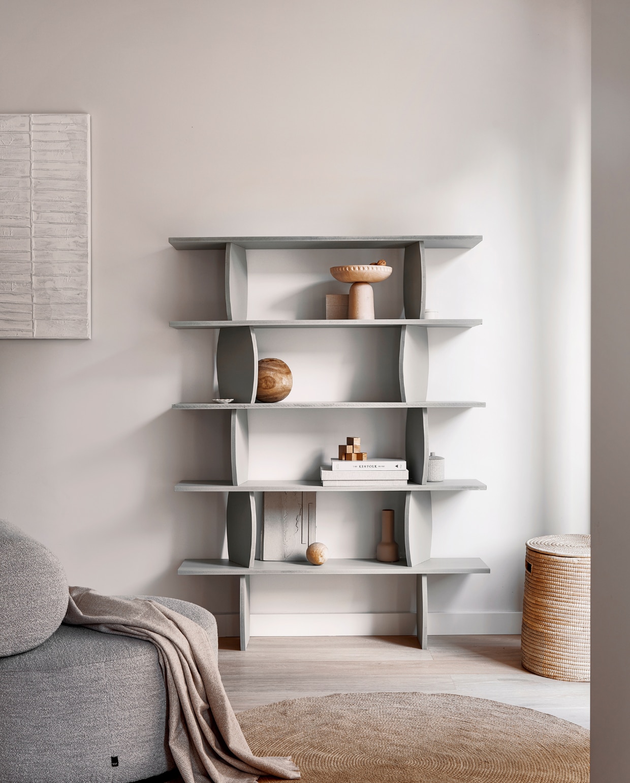 Schilderij Kave Home, vloerkleed Ferm Living. Fauteuil Sinclair in Alpine Natural Fest Amsterdam. Houten etagère Homestede. Plaid, beige pot met lijnen Zara Home. Overig privébezit. vtwonen 04-2023 | styling Sanne Ketelaar | fotografie Peggy Janssen