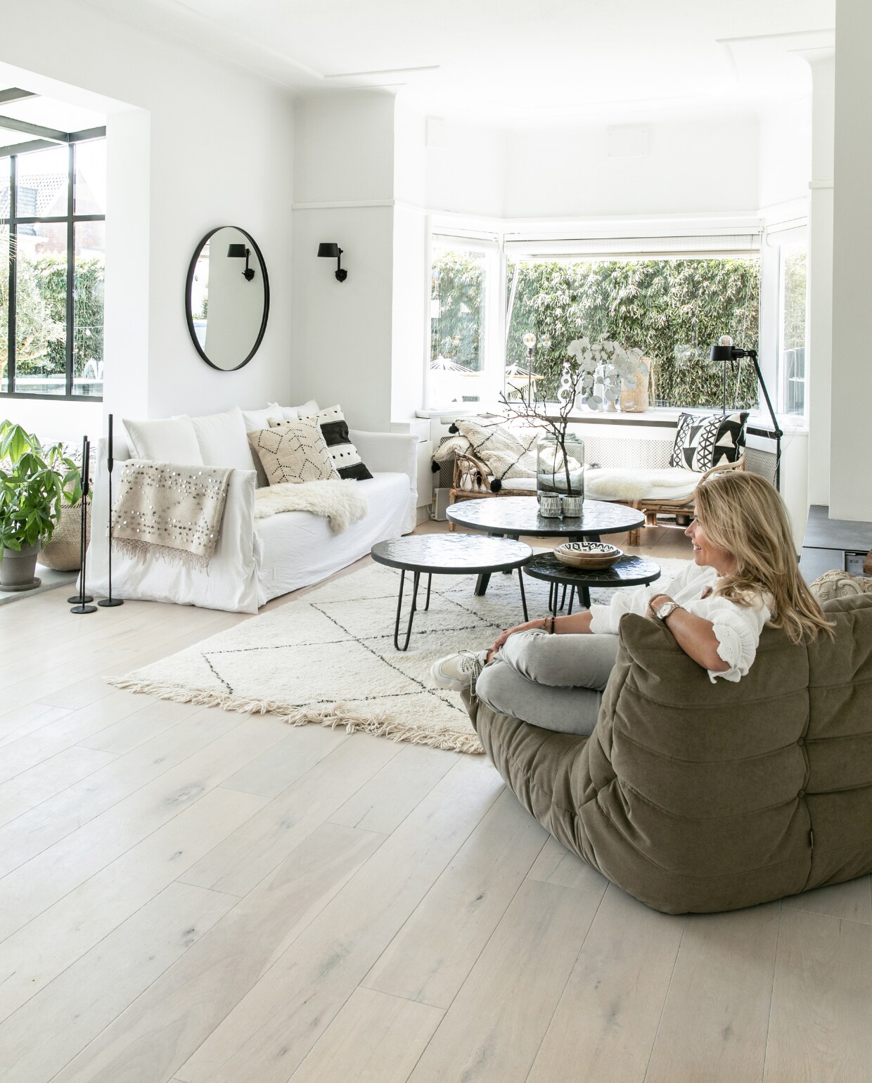 Wand- en vloerlamp Bolt van Tonone, bank Gervasoni, spiegel Sissy-Boy, kussens Sukha, berberkussens XL en plaid uit Marrakech, salontafels Zenza Home, stoel Togo van Ligne Roset, wandkleur Ral 9010, wit gelakte eikenhouten vloer. Overig onbekend. vtwonen 04-2023 | fotografie Monique Koelman