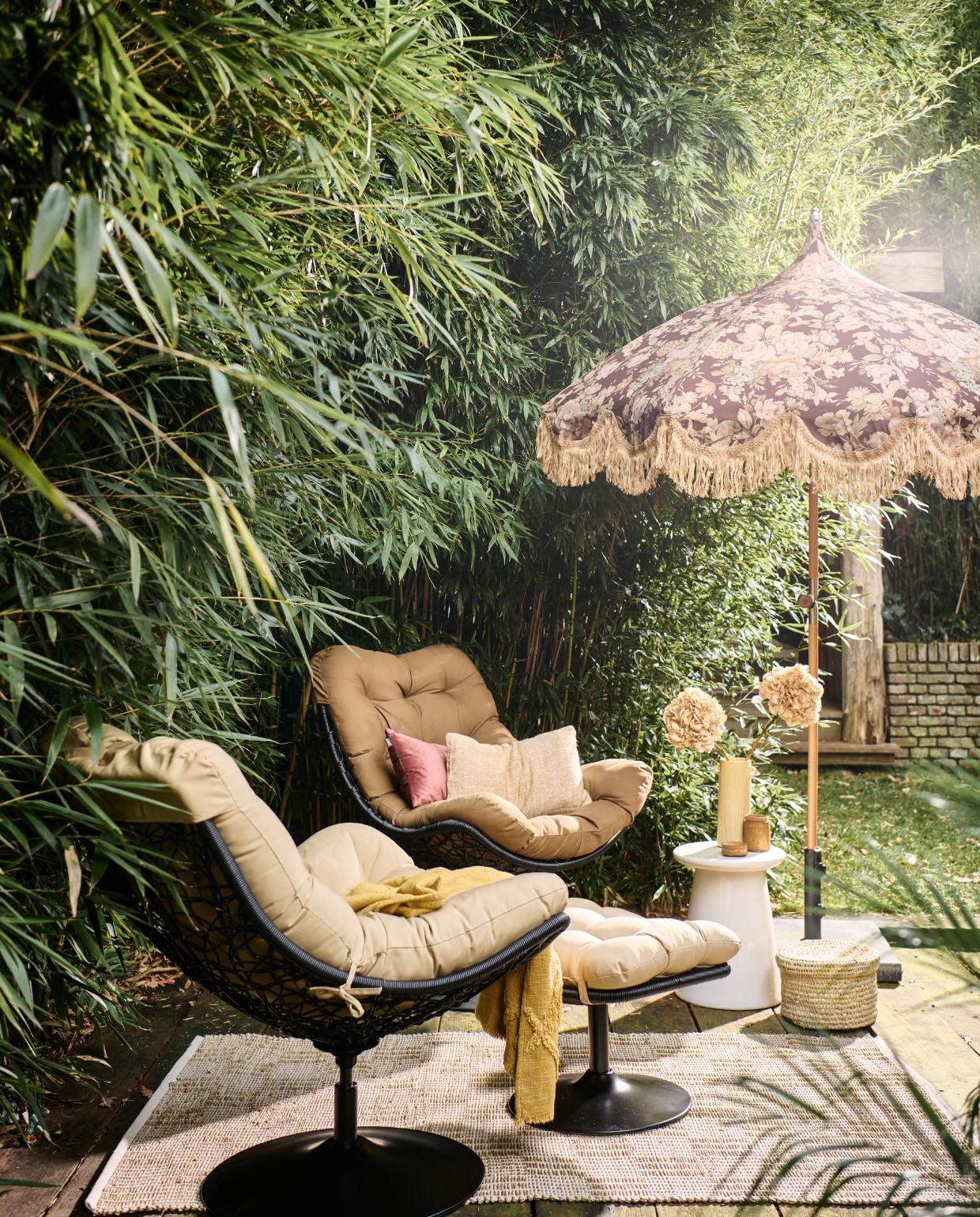 Rotan draaifauteuil Vive van Woood, met zitkussen, 82x105x100 cm (bxdxh) € 299,-, witte keramieken bijzettafel Button van vtwonen, 35x45 cm (Øxh) € 129,- (vtwonen.be/shop). Rotan hocker Vive van Woood € 149,- (basiclabel.nl). Stoffen parasol uit collectie van Marie Olsson Nylander € 395,- (hkliving.com). Rieten mand, prijs op aanvraag (com-anders.nl). Gele keramieken vaas € 54,95, geel geweven kussen, 30x50 cm € 59,95, gele geweven plaid € 59,95 (urbannatureculture.com). Roze fluwelen kussen, 30x50 cm € 39,95 (hetkabinet.nl). Houten pot met deksel € 12,50 (jolandelijk.nl). Geweven vloerkleed van Madam Stoltz, 120x180 cm € 58,24 (deens.nl). Overig privébezit. vtwonen 05-2023 | styling Marlies Does | fotografie Sjoerd Eickmans | assistentie Mandy Kimmijzer