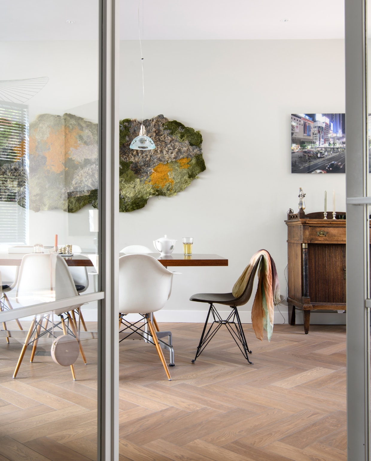 Glazen deuren met houten frame Skantrae. Tafel Neef Louis, theepot Jasper Conran voor Wedgwood, tafellamp l’Usine, eetkamerstoelen Shell Chairs van Eames voor Vitra. Wandkleed Schapenzacht, hanglamp Galileo van Lumina. Kast erfstuk, kandelaars cadeau gekregen, foto door Hein gemaakt in Tokio. Lamelparket L’intérieur Traditionnel. vtwonen 04-2023 | productie Insidehomepage | styling Inge van Lieshout | fotografie Louis Lemaire