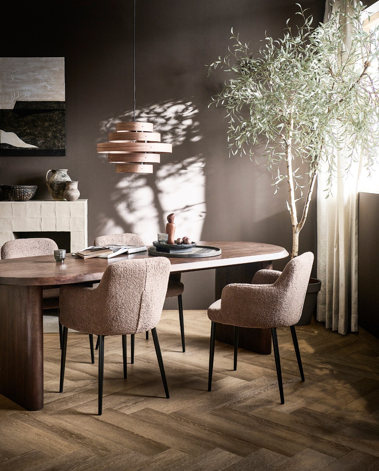 Walnootfineer eettafel Ellips, 180x90x75 cm (lxbxh) € 1299,-, ook in 240x90x75 cm (lxbxh), eetkamerstoelen Dining in taupe, teddystof en metaal, 62x53x81 cm (bxdxh) € 249,-, ook in teddystof off white.M.m.v. vtwonen.be/shop (notenhouten hanglamp van ETH, schilderij van Kave Home, houten pepermolen van Ferm Living, mangohouten bord van vtwonen, vloerkleed van Bolia), hm.com (zwart houten dienblad), karwei.nl (muurverf Warmbruin van vtwonen, gordijn Drizzle in off white van vtwonen), vtwonen.be (pvc-vloer Herringbone in Sun Kissed van vtwonen). Overig privébezit. vtwonen 05-2023 | productie Tanja Taarberg | styling Sanne Ketelaar | fotografie Sjoerd Eickmans