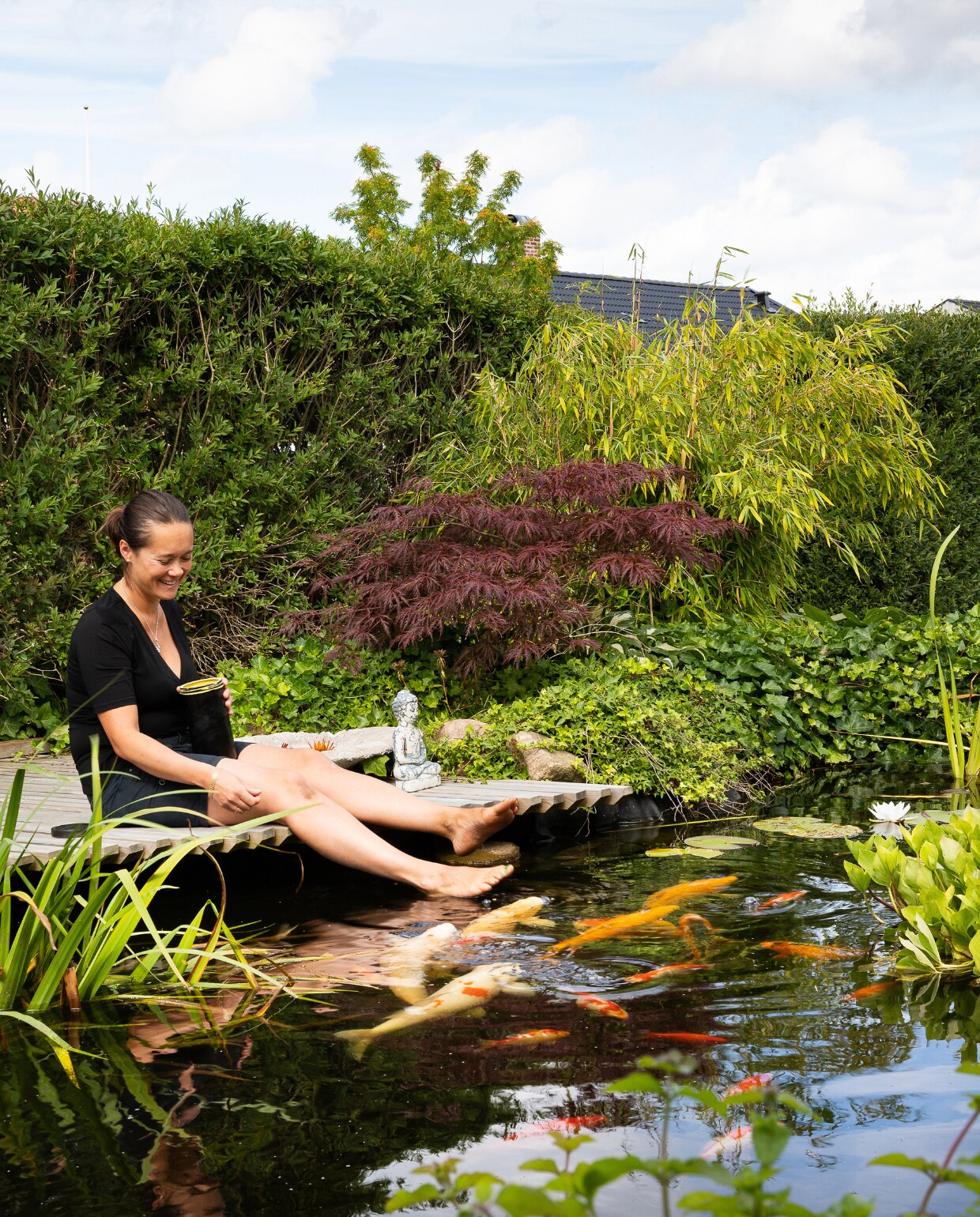 De vlonder is de perfecte plek om de bijna tamme kois te voeren. Op de achtergrond een Japanse esdoorn en parasolbamboe. vtwonen special tuin 08 | productie House of Pictures | fotografie Anna Örnberg