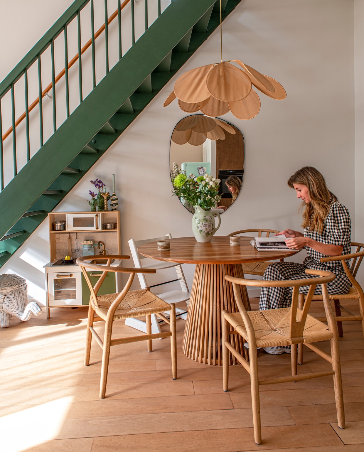 Verfkleur trap Duck Green van Farrow & Ball. Tafel Kave. Stoelen Loods 5. Kinderstoel Stokke. Hanglamp Georges. Spiegel Ferm Living. Rieten olifant Zara. Kinderkeuken Ikea. Koffiekopjes Atelier van Schaijck. Overig vintage. vtwonen binnenkijken special 131-2023 | fotografie Caroline Coehorst