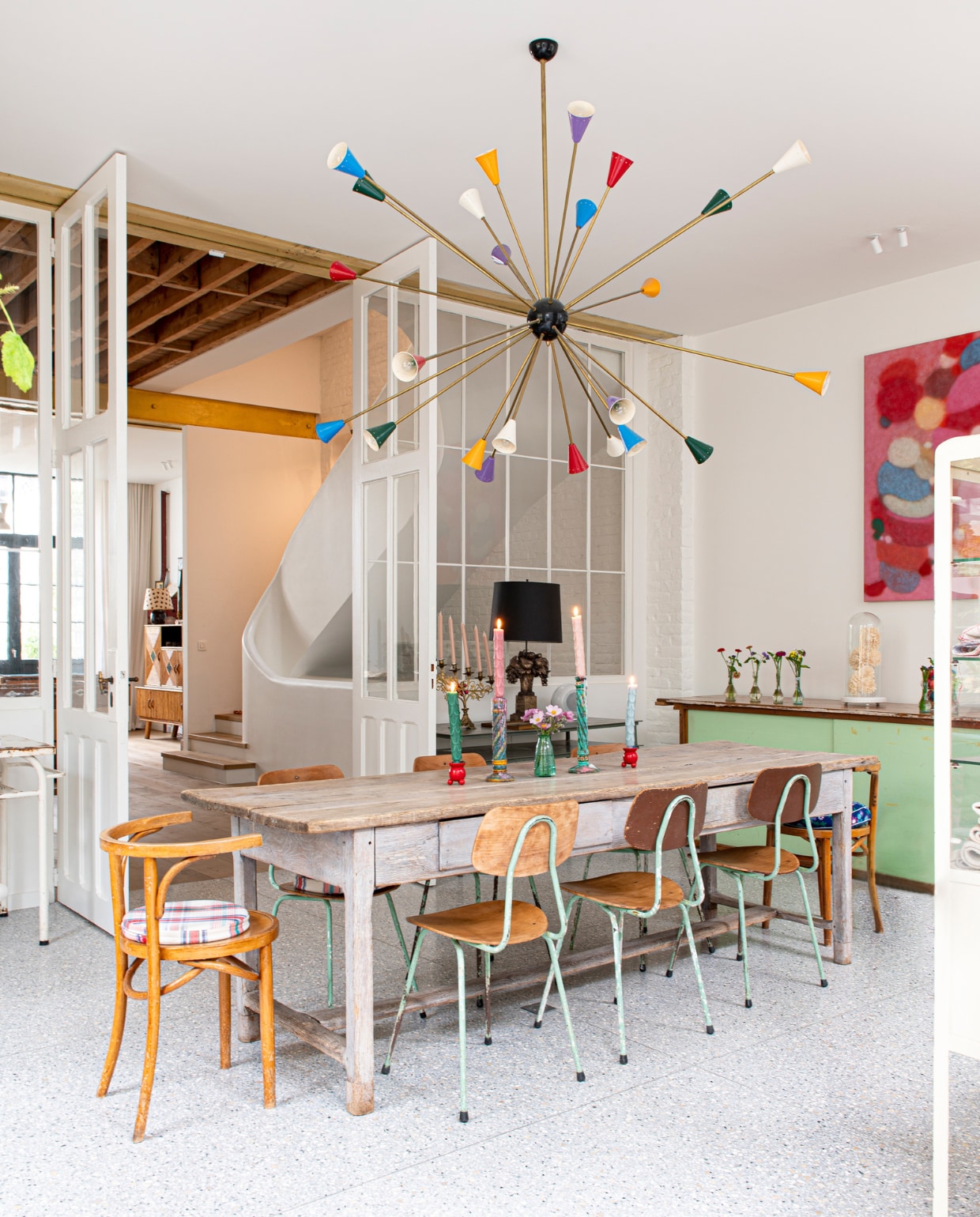 Sputniklamp  en stoelen tweedehands. Tafel en zwarte lamp cadeau gekregen. De groene kast was de toonbank van de lijstenmakerij. Overig onbekend. vtwonen special binnenkijken 03-2023 | fotografie Caroline Coehorst