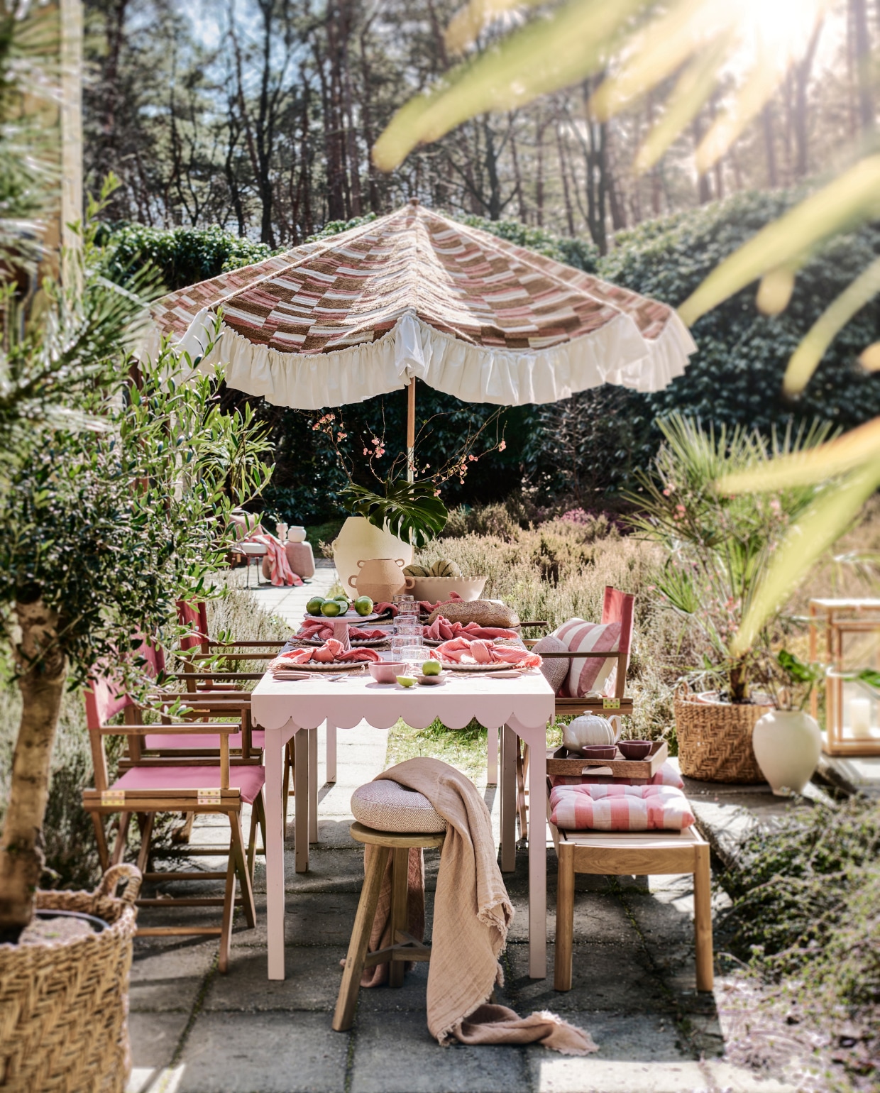 Tweedehands parasol prijs op aanvraag (com-anders.nl), met nieuwe stof Missori LR-347-21 van Elitis prijs op aanvraag (loggerewilpower.com). Tafel op maat gemaakt, prijs op aanvraag (com-anders.nl), met roze tegels Zellige Gris Rose Poisson Echelles, 10x10 cm, per m² € 179,50 (designtegels.nl). Houten kruk € 69,99, rieten placemats, per stuk € 9,99, glazen borden, per stuk € 6,99, kleine witte vaas € 39,99, manden per stuk € 89,99, witte vaas op de grond € 69,99, gestreepte kussens, per stuk € 17,99 (zarahome.com). Duurzaam teakhouten lantaarn € 499,-, duurzaam teakhouten bank € 2000,-, roze poef € 1110,-, parasolvoet € 109,-, ronde kussens 30 cm (Ø) € 150,-, (dacks.nl). Terra stalen stoel € 525,- (extravert.nl). Waterglazen, per stuk € 7,99, roze servetten, set van 2 € 12,99, onderste borden, per stuk € 9,99, roze schaaltjes, per stuk € 4,99, theepot € 29,99, houten dienblad € 39,99, roze doek op stoel op achtergrond € 22,99, roze-wit gestreepte vaas links op achtergrond € 19,99 (hm.com). Bestek Ottolenghi Feast van Serax, 24-delig € 137,-, stoelen Dalisa van Kave Home, duurzaam acaciahout en polyester, 55x43x88 cm (bxdxh), per stuk € 106,- (vtwonen.be/shop). Planten prijs op aanvraag (plantje.nl). Grote schaal € 59,99, lichtroze plateau € 39,99 (sissy-boy.com). Roze plaid op voorgrond van Maison de Vacances € 210,-, houten dienblad van Serax € 99,- (couleurlocale.eu). Houten bakje vooraan op tafel € 12,95, witte vaas met oren Sava € 169,- (urbannatureculture.com). vtwonen 06-2023 | styling Liza Wassenaar | fotografie Sjoerd Eickmans