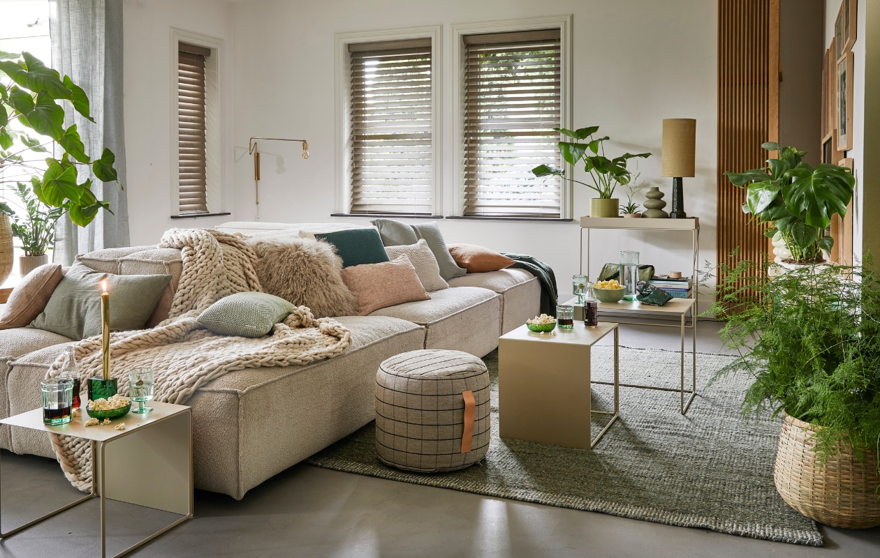 Ecru elementenbank Square van Easy Sofa, per module vanaf € 605,- (hoekbankxxl.nl). Groen geweven vloerkleed Versanti van Linie Design, 240x170 cm € 440,- (vtwonen.nl). Ecru metalen bijzettafel Cluster van Ferm Living, set van 3 € 380,-, grijze geruite poef Grid van Oyoy, 40x38 cm (Øxh) € 104,55, groene kristalglazen kandelaar Parker, 8x3x8 cm € 24,65 (wonenmetlef.nl). Crèmekleurige gebreide plaid, 152x127 cm € 149,- (noirhome.nl). Kussens van links naar rechts: lichtbruin kussen met visgraatmotief Kata van Oyoy, 40x60 cm € 57,80 (wonenmetlef.nl), linnen kussen Olive, 40x60 cm € 59,- (bymolle.com), kussen Nordic Knit van Marc O’Polo, 30x60 cm € 39,99 (vtwonen.nl), schapenvachtkussen, 40x40 cm € 69,- (noirhome.nl), groen gebreid kussen Solid van Malagoon, 50x50 cm € 49,99 (vtwonen.nl), linnen kussen Blush, 35x50 cm € 49,-, gerecycled gebreid denim kussen Sand, 40x60 cm € 79,-, linnen kussen Olive, 60x60 cm € 69,-, linnen kussen Cinnamon, 40x60 cm € 59,- (bymolle.com). Donkergroene merinowollen deken van McNutt, 200x145 cm € 100,-, groen glas van Serax, medium € 9,50, groene glazen popcornschaaltjes Emeralds, 12,5 cm (Ø), per stuk € 12,10, groen aardewerken chipsschaaltje Miscellaneous € 7,- (vanmanenaantafel.nl). Gerecycled wijnglas Oli van Ferm Living € 25,-, gerecyclede glazen karaf Oli Jug van Ferm Living € 39,-, groene kaars Dryp van Ferm Living, per 2 € 11,-, metalen plantenbak op poten Two Tier van Ferm Living, 25x75x80 cm € 299,-, fotolijsten aan rechter wand, vanaf € 35,- (byjensen.nl). Plant Philodendron, groot € 149,95, bamboe mand € 200,-, op side table plant Philodendron € 22,50, groene metalen pot € 35,-, plant rechts Monstera € 28,95, plant voor Asparagus € 44,95, bamboe mand € 89,- (stadstuindebloemenpoort.nl). Messing wandlamp Swing van House Doctor, 65x35 cm € 199,-, mosgroene keramieken vaas Eminent Circles, medium € 49,99, keramieken tafellamp Stoneware met lampenkap van HKliving € 209,-(vtwonen.nl). Terracotta bloempot Rosa, 12 cm (Ø ) € 9,50 (bymolle.com). Lichtbruin aardewerken suikerschaaltje Hagi van Oyoy (wonenmetlef.nl). Overig privébezit. vtwonen 02-2023 | styling Femke Pastijn | fotografie Peggy Janssen | assistentie Alex Lebbink