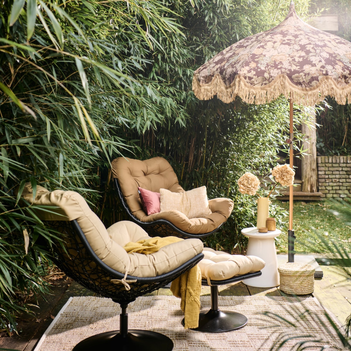 Rotan draaifauteuil Vive van Woood, met zitkussen, 82x105x100 cm (bxdxh) € 299,-, witte keramieken bijzettafel Button van vtwonen, 35x45 cm (Øxh) € 129,- (vtwonen.nl/shop). Rotan hocker Vive van Woood € 149,- (basiclabel.nl). Stoffen parasol uit collectie van Marie Olsson Nylander € 395,- (hkliving.com). Rieten mand, prijs op aanvraag (com-anders.nl). Gele keramieken vaas € 54,95, geel geweven kussen, 30x50 cm € 59,95, gele geweven plaid € 59,95 (urbannatureculture.com). Roze fluwelen kussen, 30x50 cm € 39,95 (hetkabinet.nl). Houten pot met deksel € 12,50 (jolandelijk.nl). Geweven vloerkleed van Madam Stoltz, 120x180 cm € 58,24 (deens.nl). Overig privébezit. vtwonen 05-2023 | styling Marlies Does | fotografie Sjoerd Eickmans
