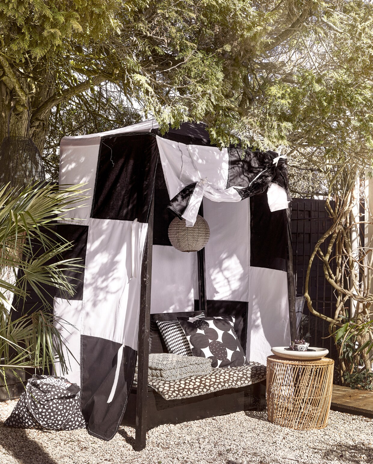 Bank met tent en matraskussen op maat gemaakt, prijs op aanvraag (com-anders.nl). Matras € 89,95, klein matraskussen Evissa € 34,95, hanglamp € 37,50 (mrsbloom.nl). Kussenhoes met cirkels Sandsenap, gemaakt door vrouwen in Jordanië, 50x50 cm € 17,99, kussen met blokdessin Stockholm € 19,99, schaal met bloemendessin € 1,99 (ikea). Rotan bijzettafel 45x44 cm (Øxh) € 349,- (hkliving.com). Tadelakt schaal € 44,95 (householdhardware.nl). Tas € 5,- (kwantum). vtwonen 06-2023 | styling Kim Timmerman | fotografie Peggy Janssen