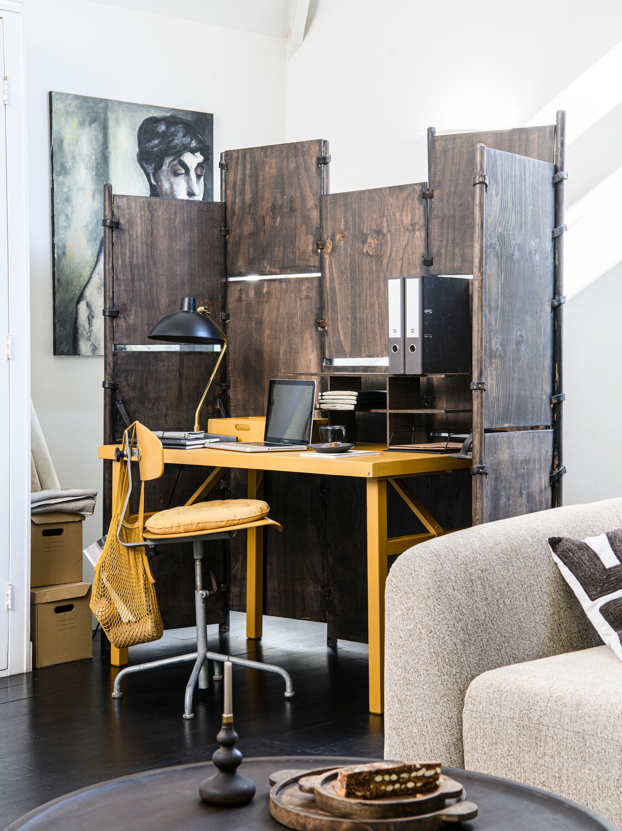 Hoekbank rechts Sloping in naturel melange van BePureHome € 1749,-, sierkussen Isla boorduur van Woood, 45x45 cm (bxh) € 39,95 (basiclabel.nl). Trigon kussen van Bepurehome met print zwart/ mosterd, 40x60 cm (bxh), mango/walnoot houten salontafel Coffee a Gogo van vtwonen € 499,-, houten set van twee dienbladen € 49,95, kandelaar Rosa van Woood, hout 28 cm € 24,95 en 22 cm € 15,95 (basiclabel.nl). Wol met katoen vloerkleed Ayaan, 170x240 cm (bxh) € 429,-, ijzeren bureaulamp Devi, 28x52 cm € 159, (dutchbone.com). Dinerkaars Curry 18 cm € 0,79 (dille-kamille.nl)In achtergrond; Uniek zesdelig kamerscherm, prijs op aanvraag, bureautafel prijs op aanvraag (com-anders.nl) geschilderd met Carazzo lak in kleur Old Ochre, per liter € 77,30 (pure-original.com). Rekje, prijs op aanvraag, vintage bureaustoel prijs op aanvraag (com-anders.nl). Okergeel stoelkussen, rond € 12,95, geel katoen nettasje, € 7,95 (dille-kamille.nl). Styling Marit Saladini | Fotografie Louis Lemaire
