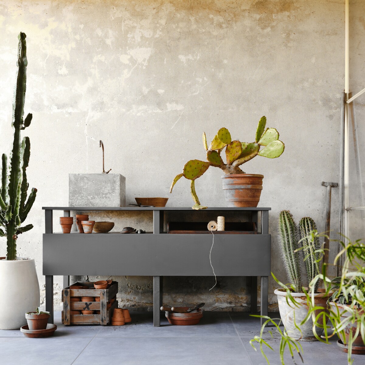 Tuintegel Solostone Mold Basalt van vtwonen, 70x70 cm (ook in de kleuren Taupe en Grit). M.m.v. com-anders.nl (werkbank/buitenkeuken inclusief wasbak en kraan), intratuin.nl (terracotta bloempotten). Overig privébezit. vtwonen 03-2023 | productie Tanja Saarberg | styling Marlies Does | fotografie Bart Brussee