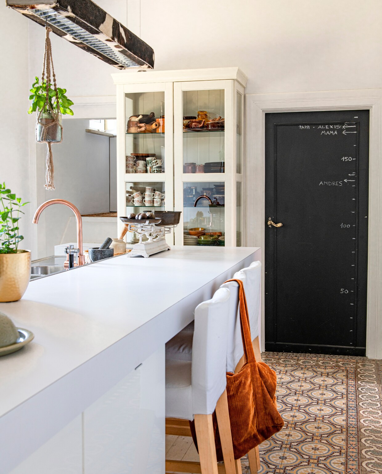 Keuken, vitrinekast, krukken en juten plantenhanger Ikea. Lamp D-cow van Dark, roze kraan Brico. Weegschaal en serviesgoed in de kast uit de kringloopwinkel. vtwonen 06-2023 | productie De Binnenkijkers | styling Jeske Weel | fotografie Caroline Coehorst