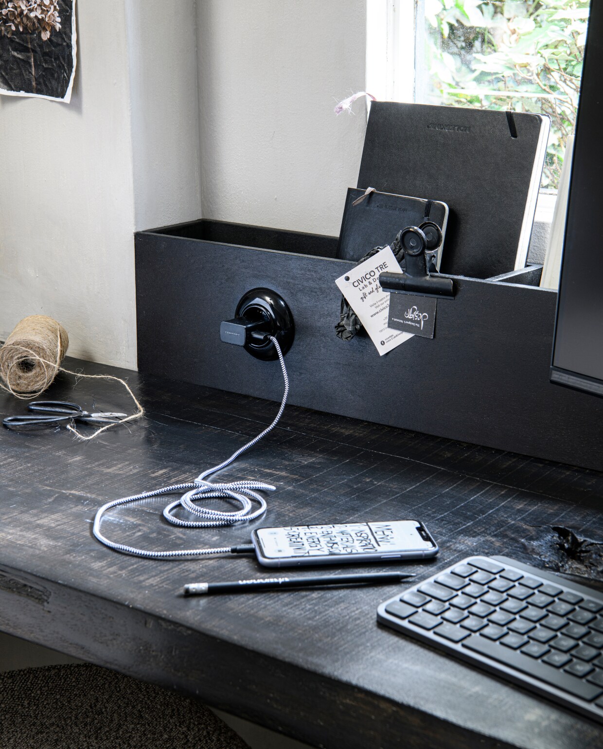 Zwarte 18 maanden weekplanner 18M € 31,90 (moleskine.nl). Keyboard Logitec, clip,  Iphone, vtwonen potlood, schaartje en touw (prive bezit). iPhone laadsnoer USB laadkabel 8-pin textielsnoer € 17,50 (hema.nl). Zwart stopcontact met randaarding € 9,90, zwart rond afdekraam 1-voudig € 6,90 (deoudeschakelaar.nl). styling Marit Saladini | fotografie Louis Lemaire | assistentie Rosa van Schie, Kiki de Koning | uitvoering opbergbak Johan Snoodijk