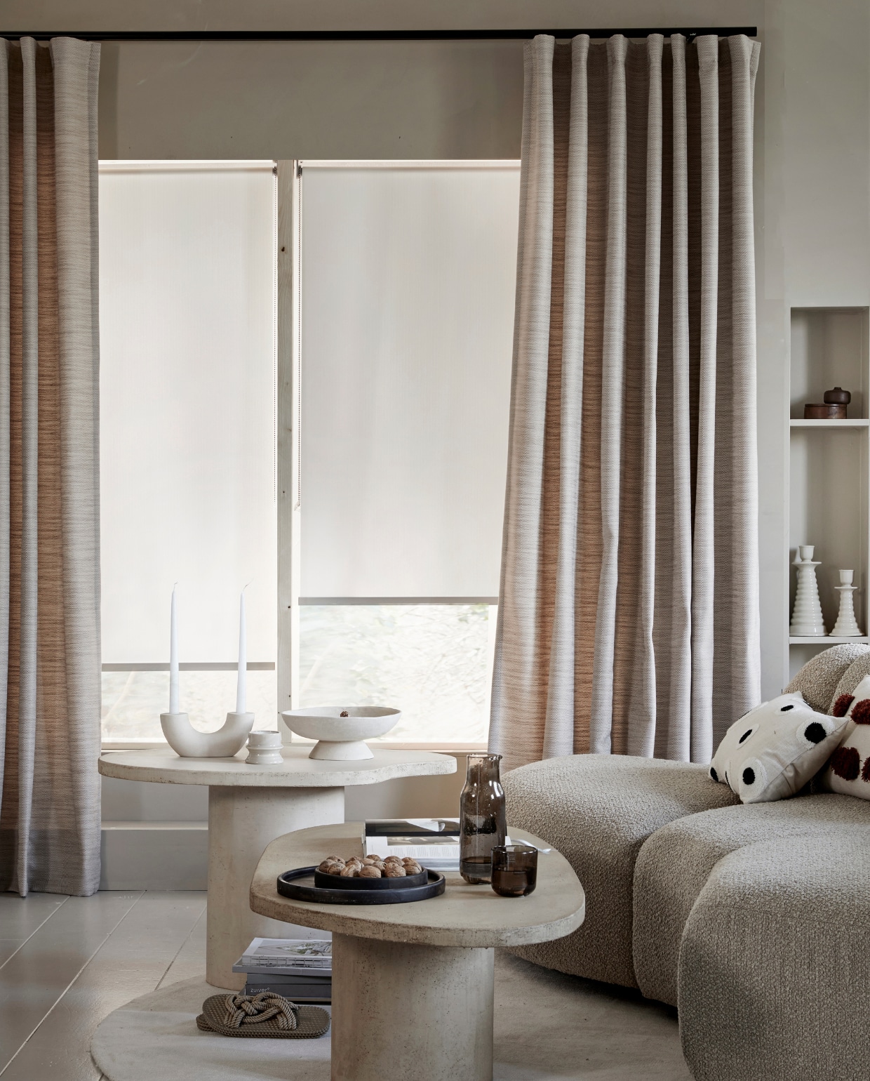 Lichtdoorlatend gordijn op maat met wave plooi in stof Sprinkle (1171), kleur Zand vanaf € 33,99 per strekkende meter. Lichtdoorlatend rolgordijn op maat wit visgraat (18012) vanaf € 128,19. M.m.v.: hkliving.nl (elementenbank Jax), vtwonen.be/shop (kussen met stippen), bogard.eu (salontafel Palet, salontafel Steen). vtwonen 06-2023 | productie Tanja Saarberg | styling Marit Saladini Platjouw | fotografie Peggy Janssen