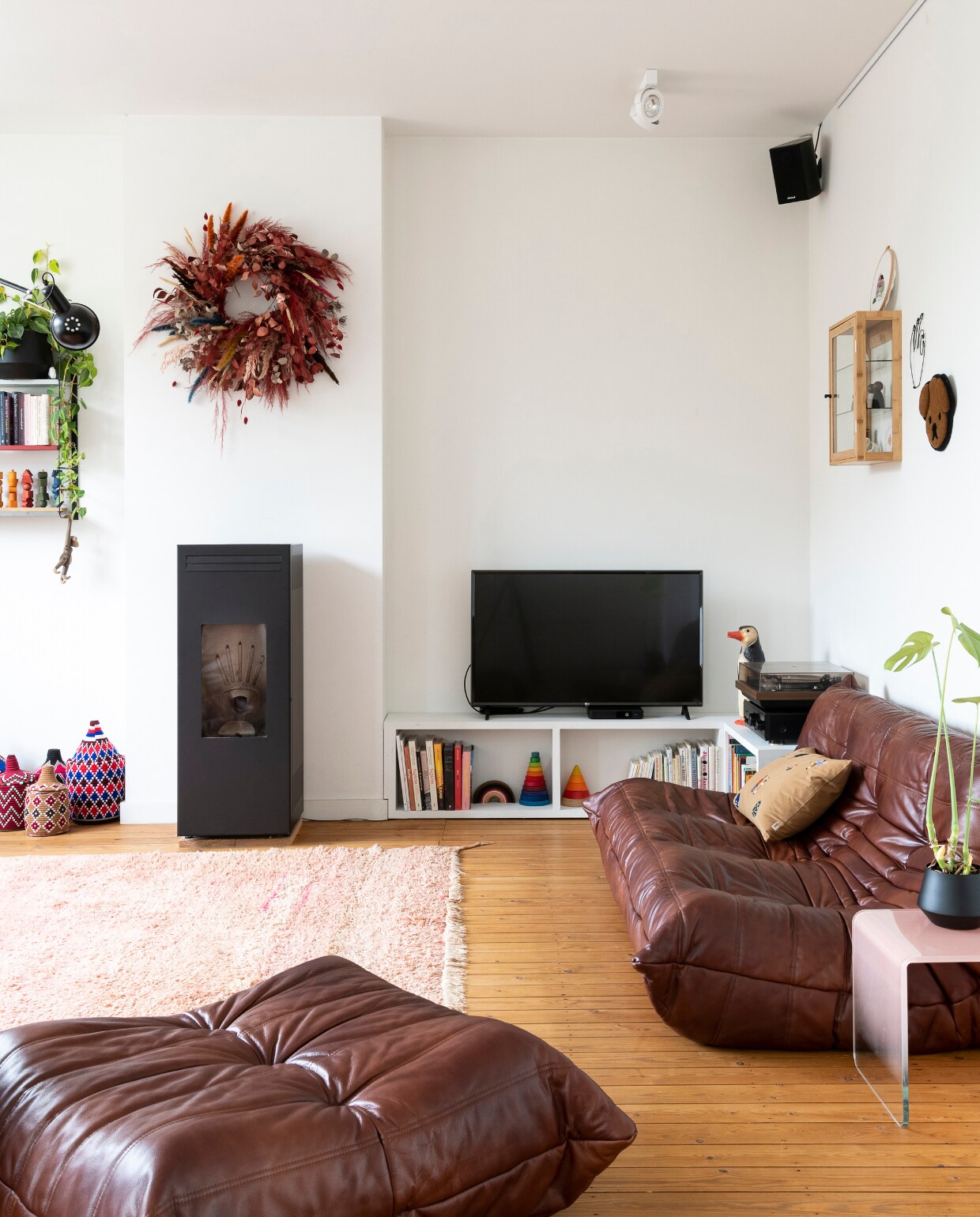Zitelementen Togo van Ligne Roset, kussen Ferm Living, pelletkachel CMG, vloerkleed Maghribi Mood. Vintage wandrek Tomado, kleurige manden Petit Maroc, tv-meubel zelfgemaakt. Speelgoed van Grimm’s, PlanToys en Dëna. Bijzettafel Made, vitrinekast Jysk, wandkleed hond Maison Deux, krans Anne Engels, pinguïnlamp Heico. Vloer (originele) grenen planken met kleurloze olie. vtwonen 06-2023 | styling &amp; fotografie Jonah Samyn