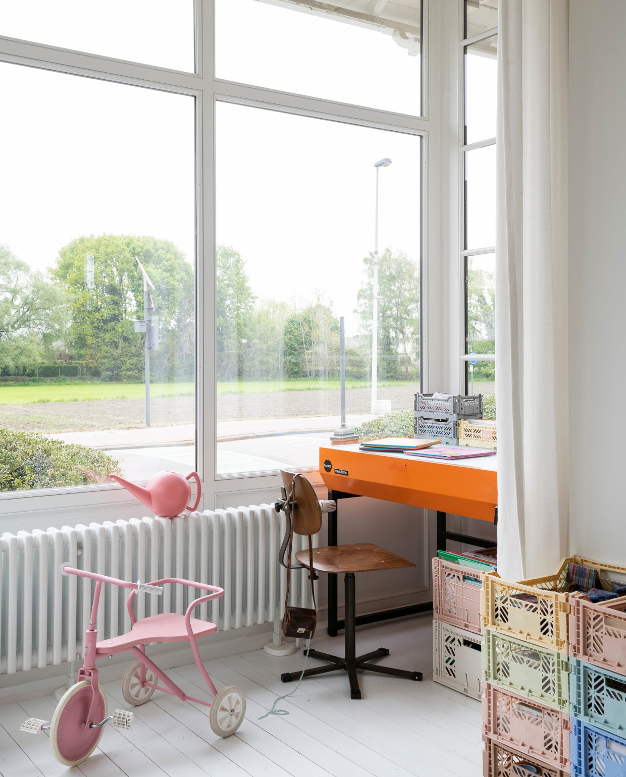 Bureaustoel sis.antwerp, oranje lichtbak 2dehands, driewieler Foxrider, kratten Hay, gordijn Ikea, gieter Loods 5, vloer nieuwe grenen planken wit geverfd. vtwonen 06-2023 | styling &amp; fotografie Jonah Samyn