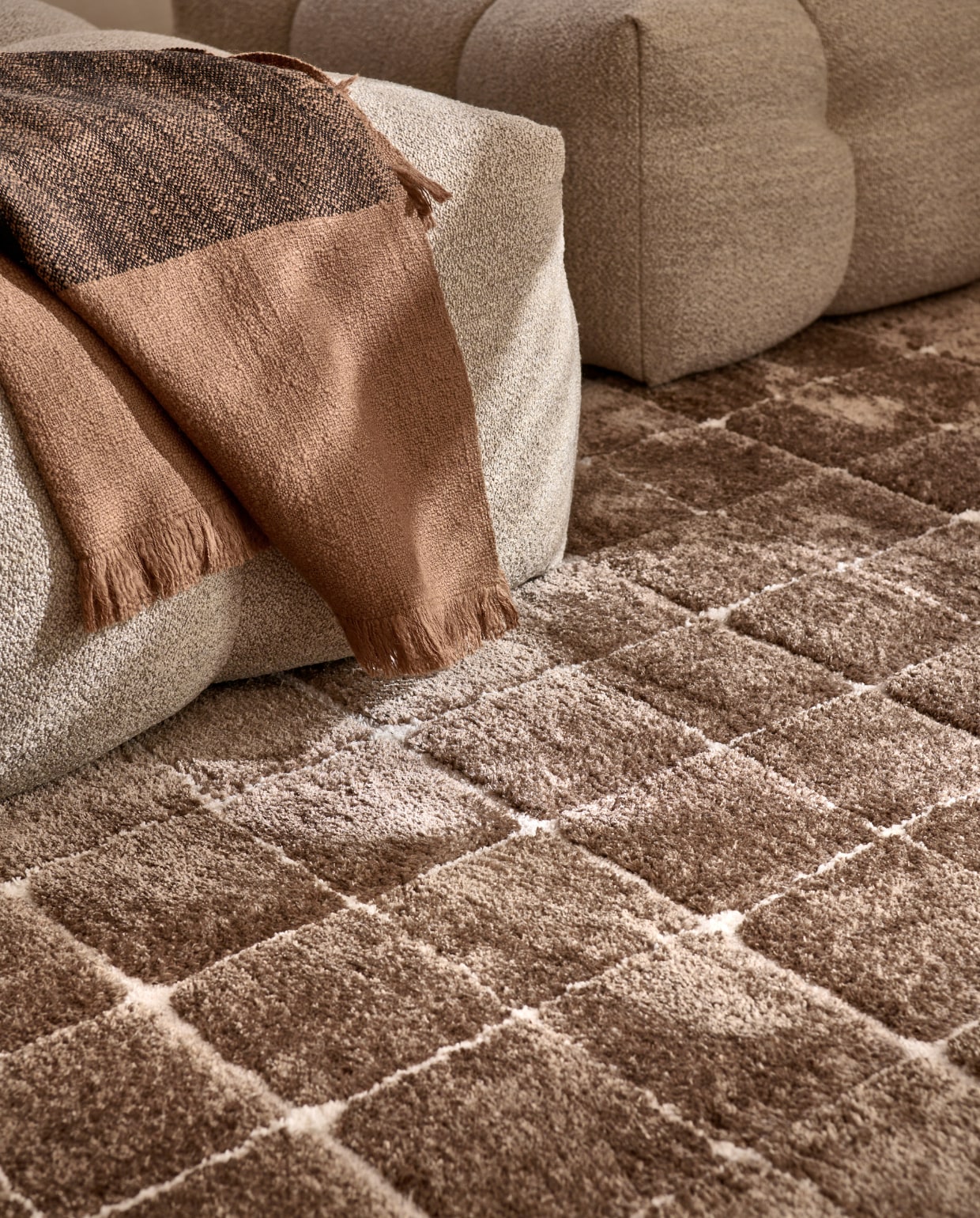 Vloerkleed Blocks in Warm Brown, polyester en jute, 240x330 cm. Ook verkrijgbaar in Warm white. M.m.v. studiohenk.nl (fauteuil), vtwonen.be/shop (plaid van Ferm Living). vtwonen 06-2023 | productie Tanja Saarberg | styling Sanne Ketelaar | fotografie Sjoerd Eickmans | assistentie Evans van der Sluis