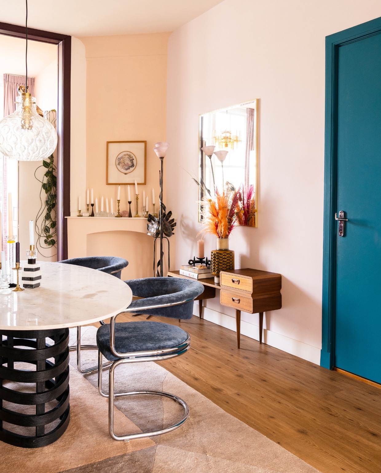 Verfkleur muren 2/3 van AN.02.81 Sikkens, schouw E04.07.82 van Flexa en deur Q2.41.34 van Sikkens. Eettafel en vloerkleed tweedehands. Zougoise Victoria-stoelen Enter My Attic. Marmeren kandelaar @hildamadeitwithcare. Hanglamp Glashütte Limburg, wandkast, overige kandelaren en vaas Sprinkelhop. Bellart Italy-vloerlamp Mippies. Spiegel Vintage Pareltjes. Kunstwerk boven schouw gemaakt door Jokes oma. vtwonen special binnenkijken 03-2023 | productie CocoFeatures | fotografie Muk van Lil