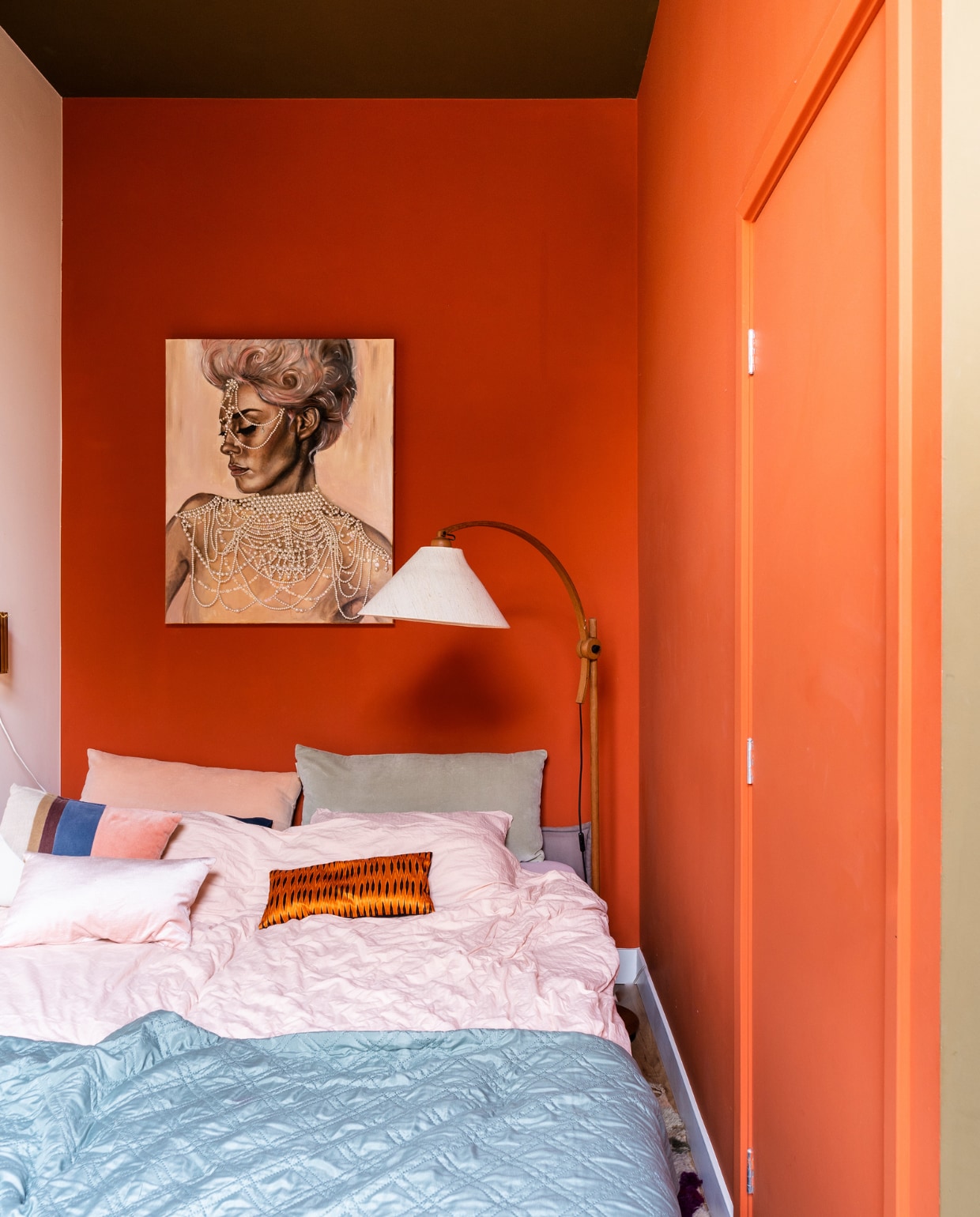 Muurverf links E04.07.82 van Flexa, rechts D3.55.38 en plafond F6.30.30 van Sikkens. Kunstwerk Let Them Eat Pearls van Tess Anders. Vloerlamp Domus Sprinkelhop.  Dekbedovertrek Crisp Sheets. Gestreept kussen HKliving. Oranje kussen Mariska Meijers. Overig onbekend. vtwonen special binnenkijken 03-2023 | productie CocoFeatures | fotografie Muk van Lil