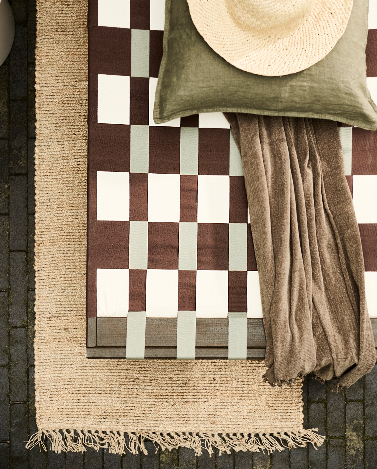 Grenenhouten frame daybed, 200x70x31,5-77 cm (lxbxh) € 67,99 (vidaxl.nl). Parasol van HKliving € 369,- (bijenkorf.nl). Grijze bloempot van Elho € 145,-, bijzettafel van HKliving € 249,- (vtwonen.be/shop). Plaid € 24,99, kussen € 12,99, juten vloerkleed € 42,99 (hmhome.nl). Glazen karaf € 17,99, houten dienblad € 17,99, glas € 5,99 (zarahome.com). Overig privébezit. vtwonen 06-2023 | styling en uitvoering Sanne Ketelaar | fotografie Sjoerd Eickmans