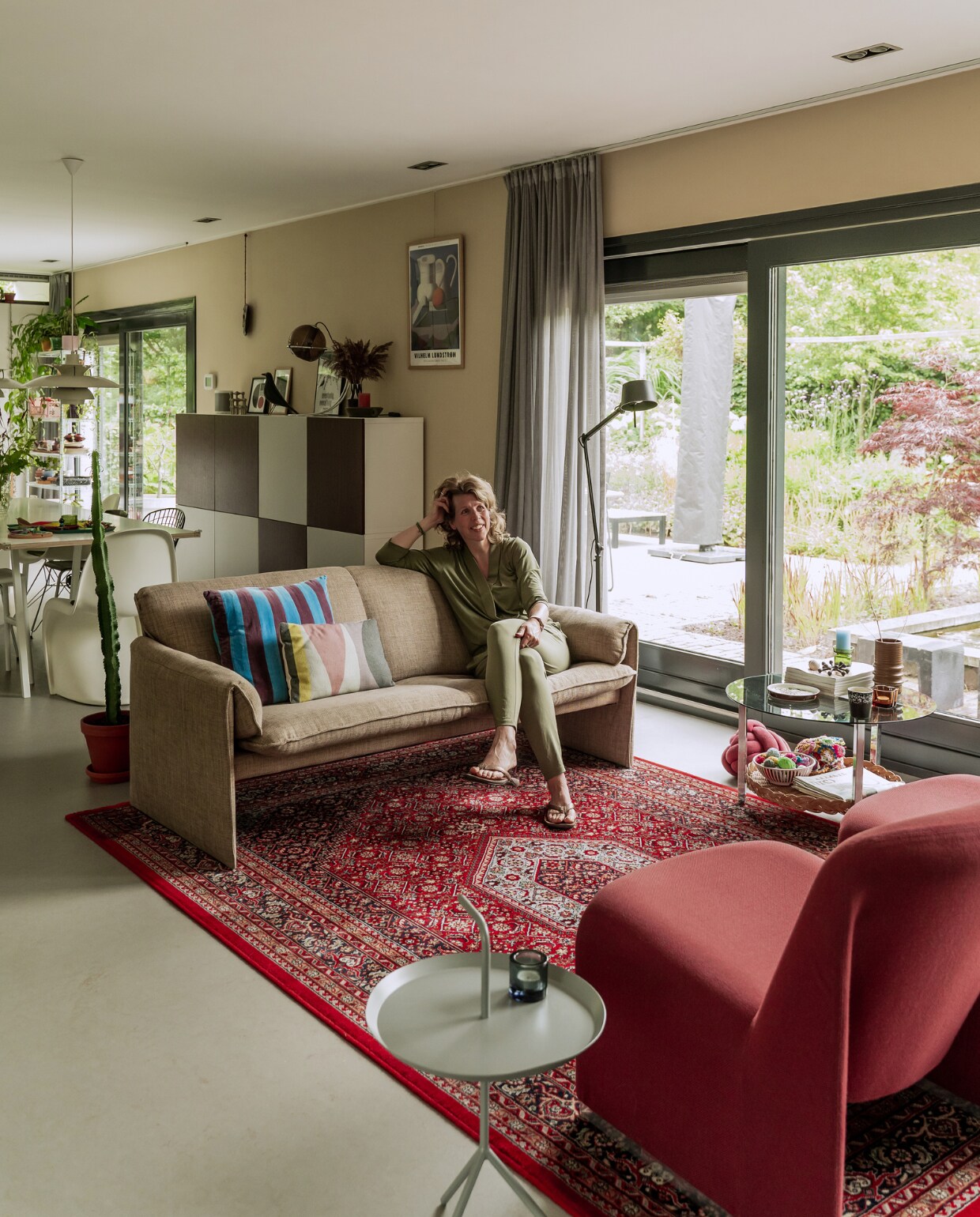 Verfkleur Dune van Painting The Past. Vloer Dutch Design van Forbo Flooring in kleur Jurgen Bey. Vintagebank Bora Bora van Leolux Decennia Design. Gestreept kussen HKliving. Rechthoekig kussen Fést. Perzisch tapijt, rotan bijzettafel, bruine vaas en Jens Quistgaard-waxinelichthouders tweedehands. Fauteuils Alky van Artifort. Bijzettafel Hay. Waxinelichthouder Iittala. Kast Besta van Ikea, zelf beplakt met folie. Overig onbekend. vtwonen special binnenkijken 03-2023 | productie CocoFeatures | styling Laurien Deken | fotografie Inge Korver