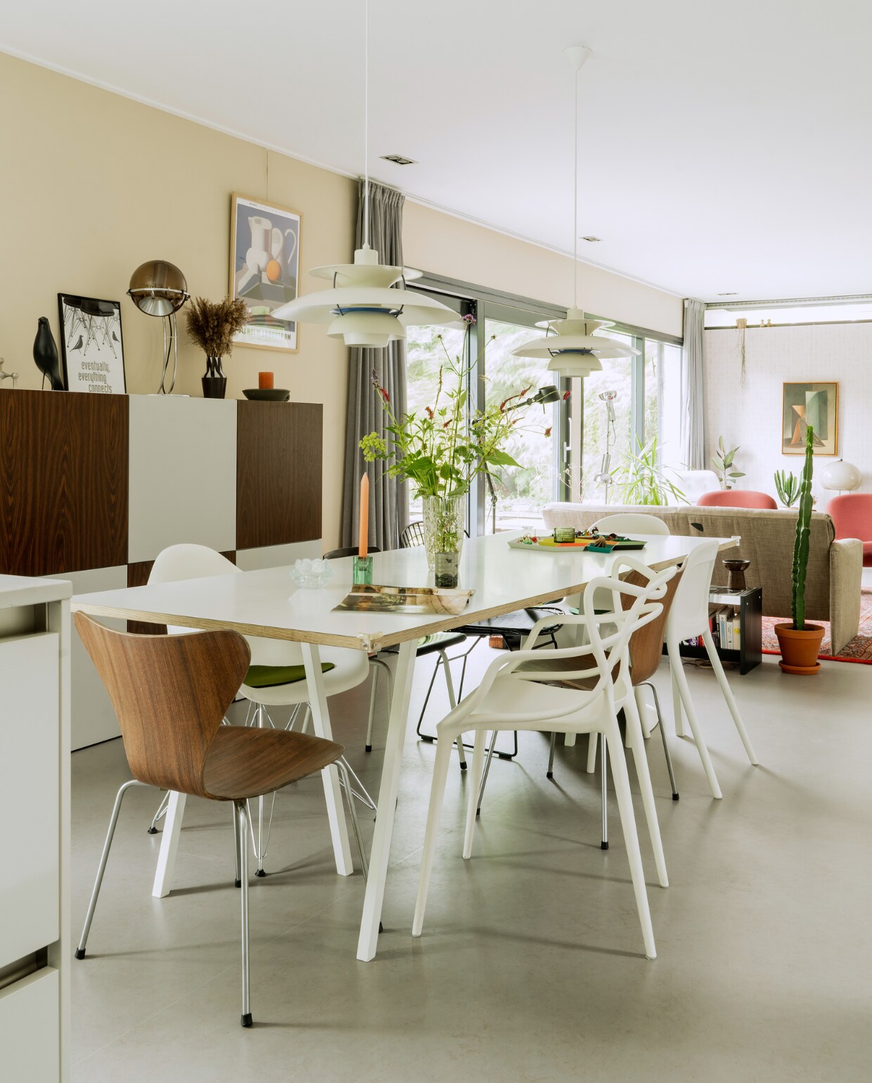 Tafel Loop Stand Hay. Eetkamerstoelen vintage Arne Jacobsen, Masters van Kartell en DAR van Eames voor Vitra. Vintage hanglampen PH5 van Louis Poulsen. Vaas, theemok en waxinelichthouder kringloop. Eames-vogel cadeau gekregen. Lamp Globe van Frank Ligteleijn voor Raak. Vaas op kast Ouderwets Gezellig. Poster van Vilhelm Lundstrom van het Deense kunstmuseum Brandts. Overig onbekend. vtwonen special binnenkijken 03-2023 | productie CocoFeatures | styling Laurien Deken | fotografie Inge Korver