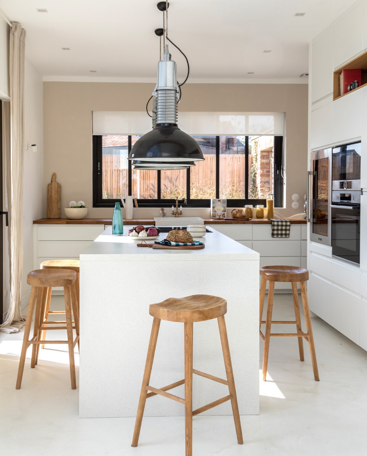 Keuken Ikea, beige muurverf Leroy Merlin, barkrukken Zara Home, plafondspots Philips, industriële hanglampen uit een oude fabriek, wijn-koelkast Klarstein, oven Bosch. Overig onbekend. vtwonen 06-2023 | productie AC Scoffoni | styling Marie-Maud Levron | fotografie Cecile Perrinet-Lhermitte
