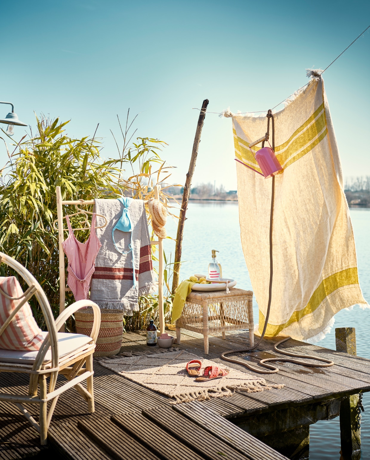 Handgemaakt laurierhouten handdoekenrek uit Marokko, beige tafelkleed met streep Libeco, beige plaid met gele streep Towel, raffia pet, kruk Malawi, bamboe en rotan, geel servet Ocher, gevlochten mand (couleurlocale.eu). Houten schaaltje, 11 cm (Ø), roomwitte tadelakt schaal, rotan stoel met kussen (householdhardware.nl). Oranje-wit gestreept kussen, 50x50 cm, tuinslang Deluxe, 15 m (l) (hm.com). Roze gieter, prijs op aanvraag (sissy-boy.com). Juten vloerkleed van Nordal, 60x40 cm (nordal.dk). Slippers Level van Dune London, badpak van Beachlife, bamboe badborstel van Wellmark, natuurspons Ocean van Mette Ditmer, set van 5, vegan zeep, blauw zwemtopje van Seafolly (bijenkorf.nl). Bamboe kledinghanger (weldaad.com). Takken, prijs op aanvraag (waterdrinker.nl). vtwonen 07-2023 | Styling Liza Wassenaar | Fotografie Sjoerd Eickmans