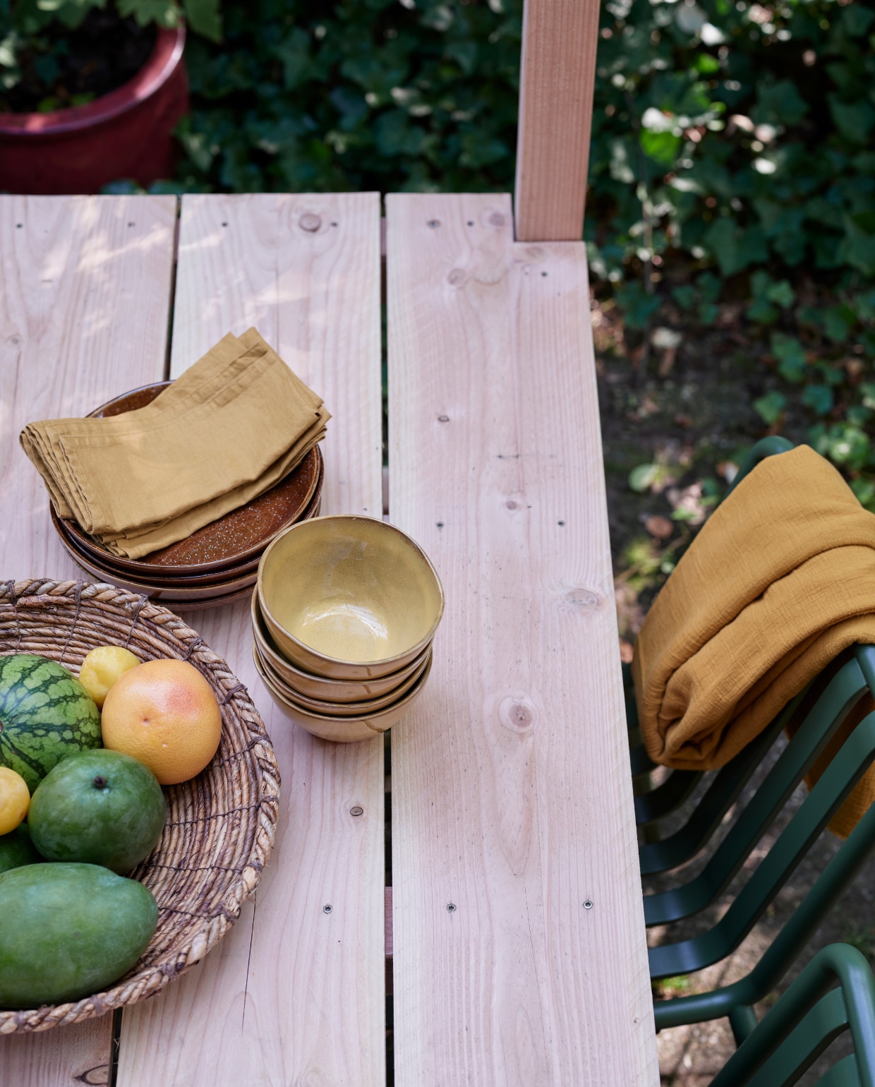 Foto’s deze en vorige pagina: tuinbank Luxembourg van Fermob, stoelen Palisade Chair van Hay (vtwonen.nl). Tafelkleed van okergele stof (patickkarteris.nl). Hoge vaas, diepe borden Glaze (kwantum.nl). Bamboe lantaarn, schaaltjes, schaal (intratuin.nl). Sisal schaal (hm.com). Linnen servetten (hm.com). vtwonen tuin special 5 2022 | diy large | Styling Moniek Visser | Fotografie Sven Benjamins