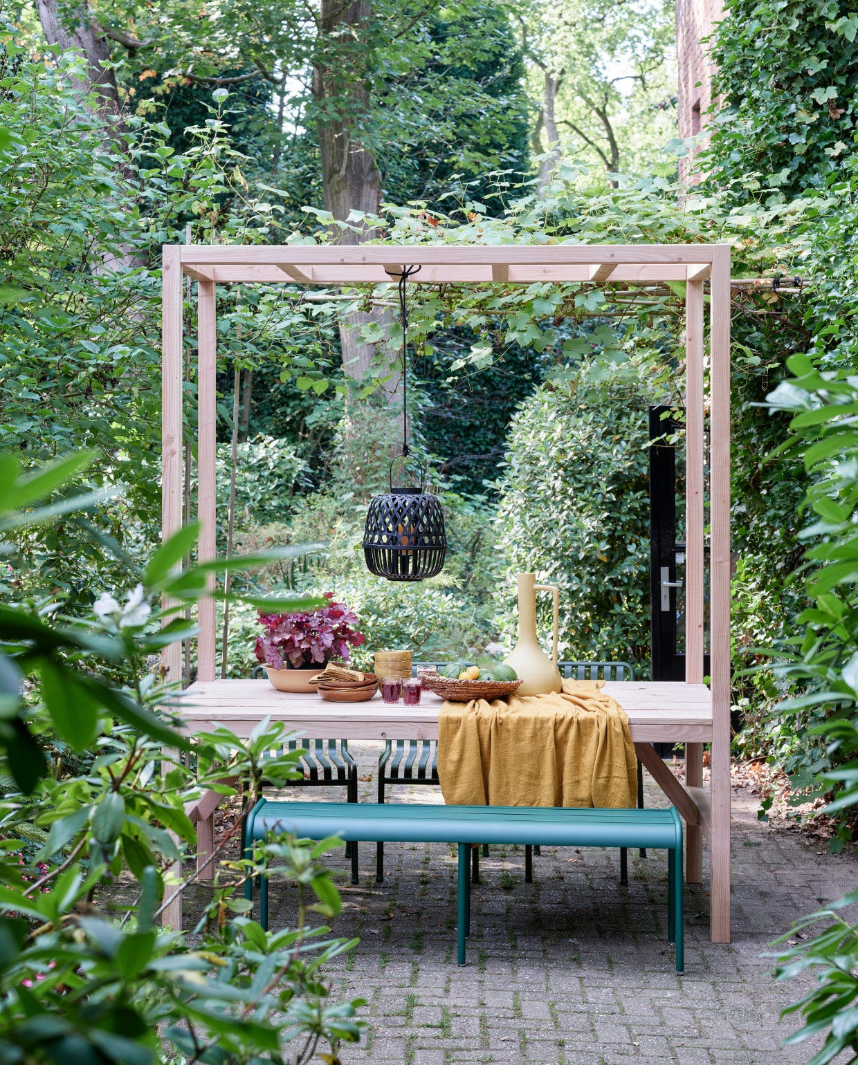 Foto’s deze en vorige pagina: tuinbank Luxembourg van Fermob, stoelen Palisade Chair van Hay (vtwonen.nl). Tafelkleed van okergele stof (patickkarteris.nl). Hoge vaas, diepe borden Glaze (kwantum.nl). Bamboe lantaarn, schaaltjes, schaal (intratuin). Sisal schaal (hm.com). Linnen servetten (hm.com). vtwonen tuin special 5-2022 | diy large | styling Moniek Visser | fotografie Sven Benjamins